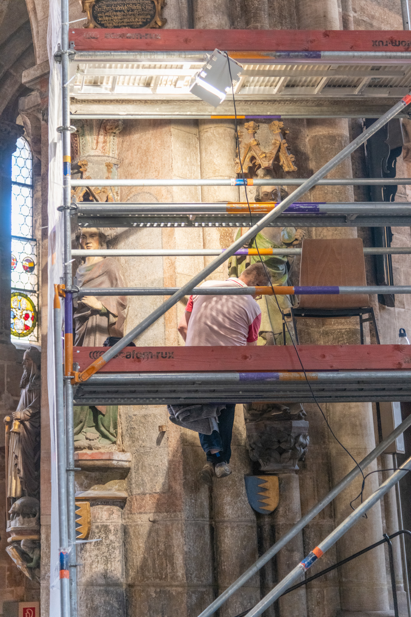 Restoration worker restoring a status in St Sebald Church