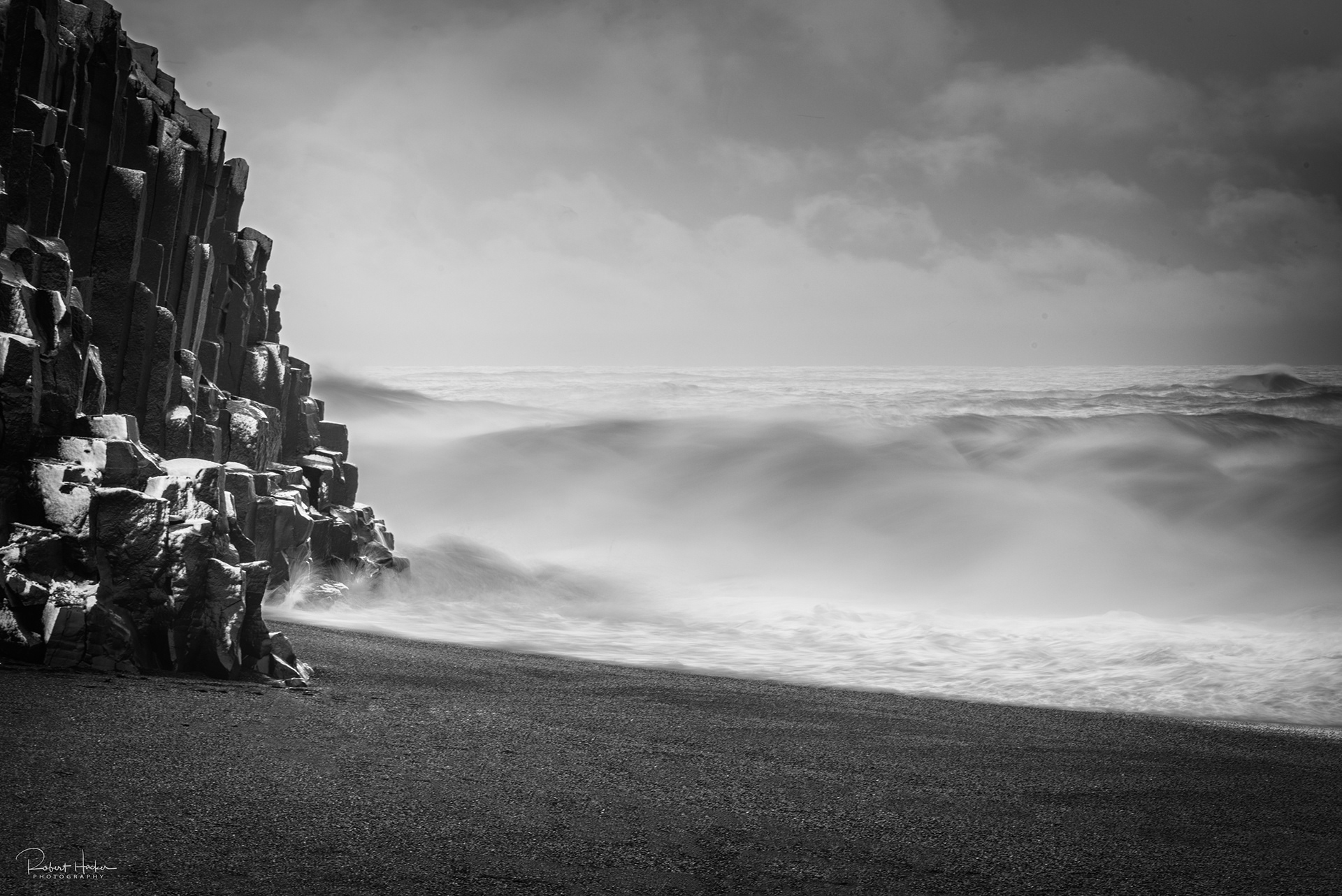 Basalt cliffs and crashing surf at Reyniskirkja Beach