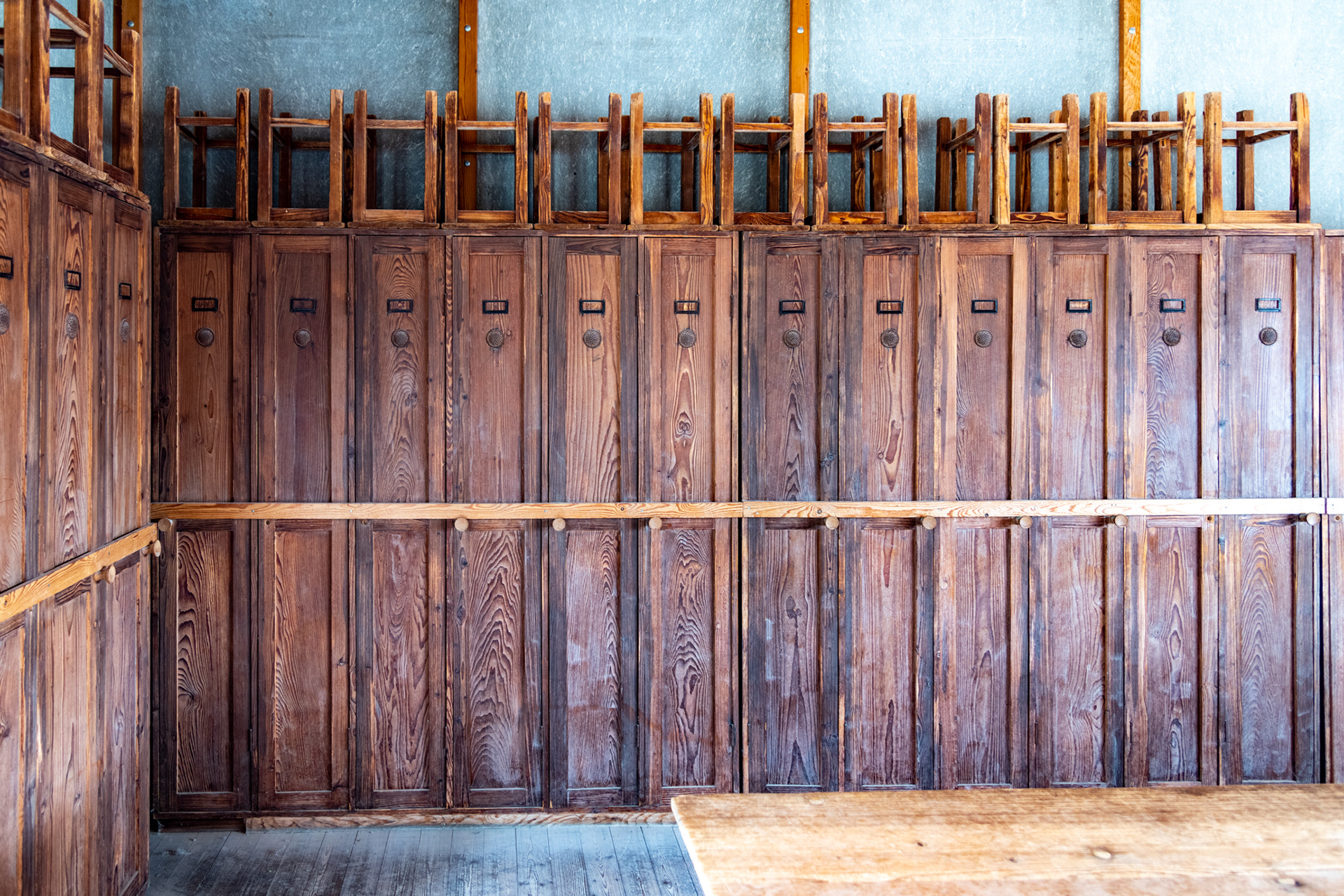 Prisoner lockers and stools in the barrack common room.