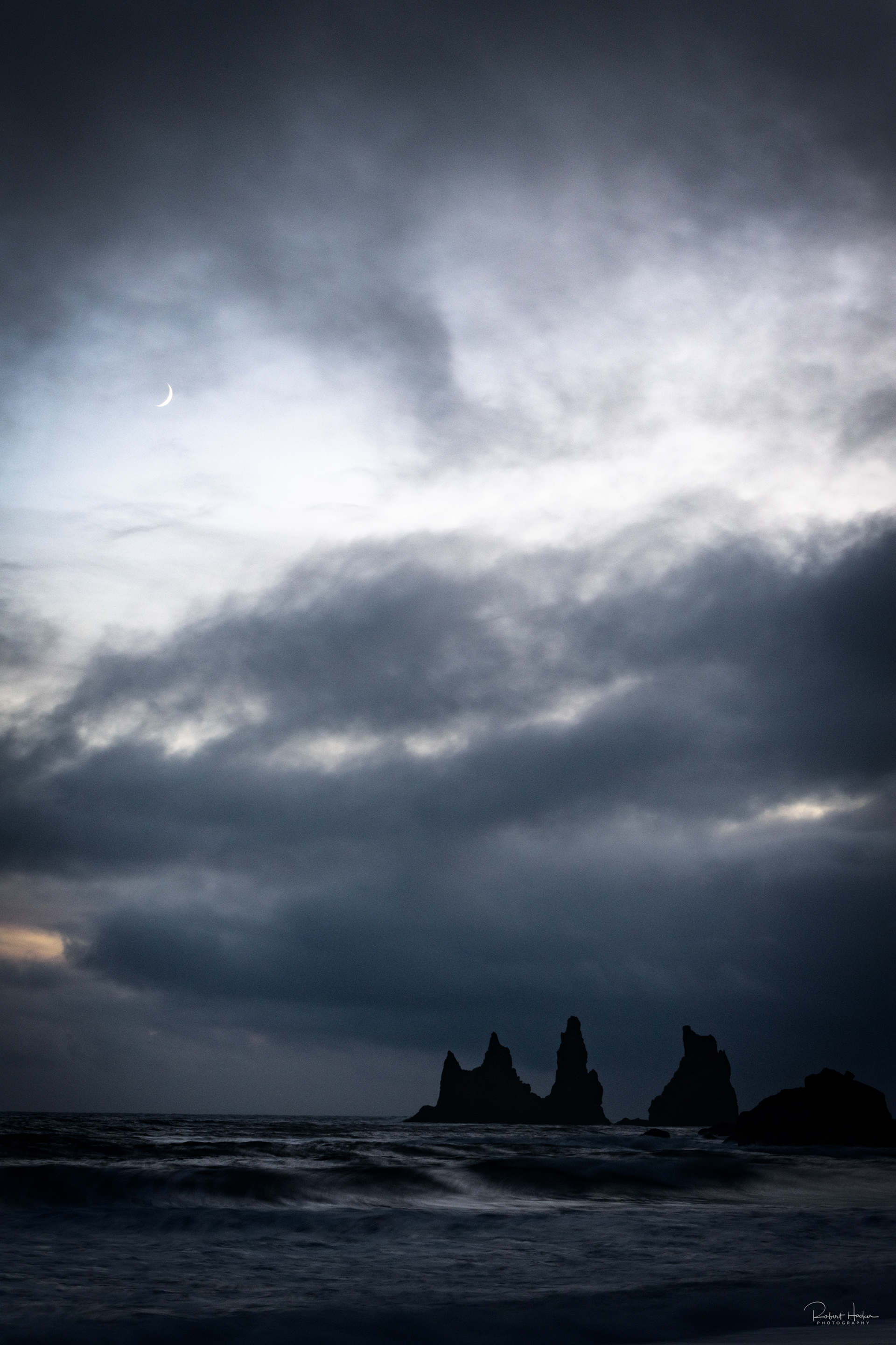 Sea stacks near the black sand beach in Vik on the south coast with a crescent moon