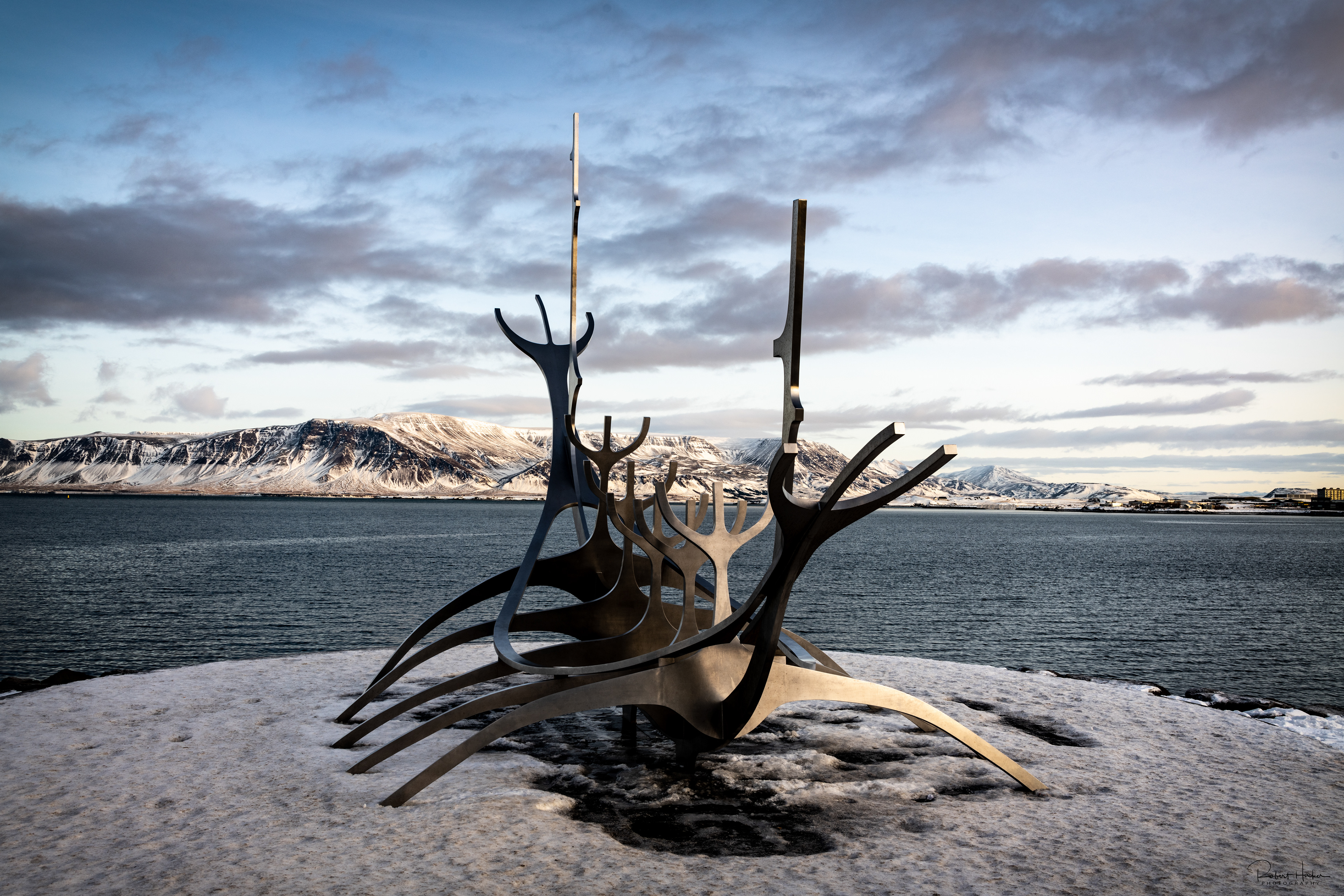 Solfarid (Sun Voyager) sculpture on the bay at Reykjavik with Mount Esja in the background.  The sculpture represents a dream boat and an ode to the sun. It represents the promise of undiscovered territory and a dream of hope, progress and freedom.
