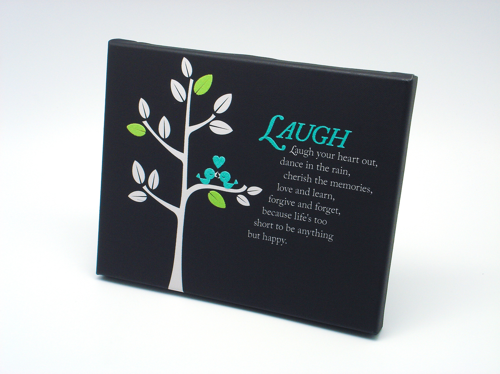 Laugh inspirational quote and birds in tree graphic on black canvas material.