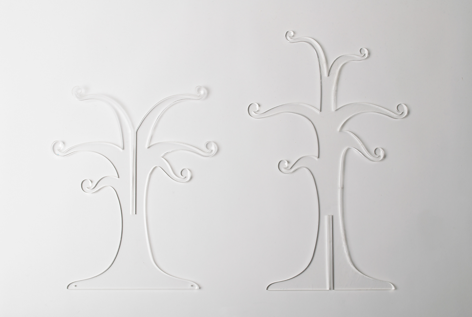 Clear acrylic tree stand in disassembled and lying flat in two pieces. 