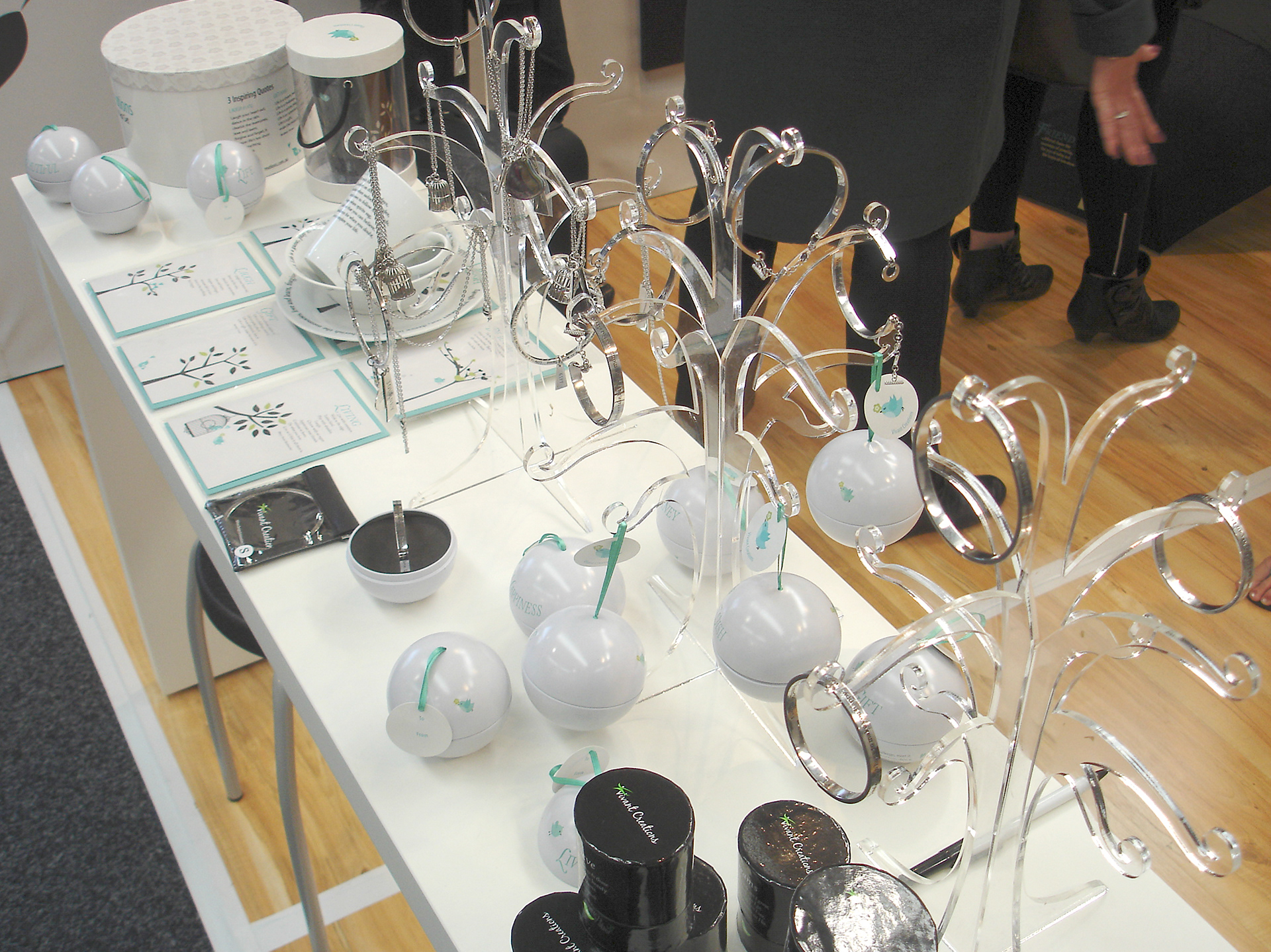 Three tree shape jewellery display stands loaded with products at a trade show display booth.