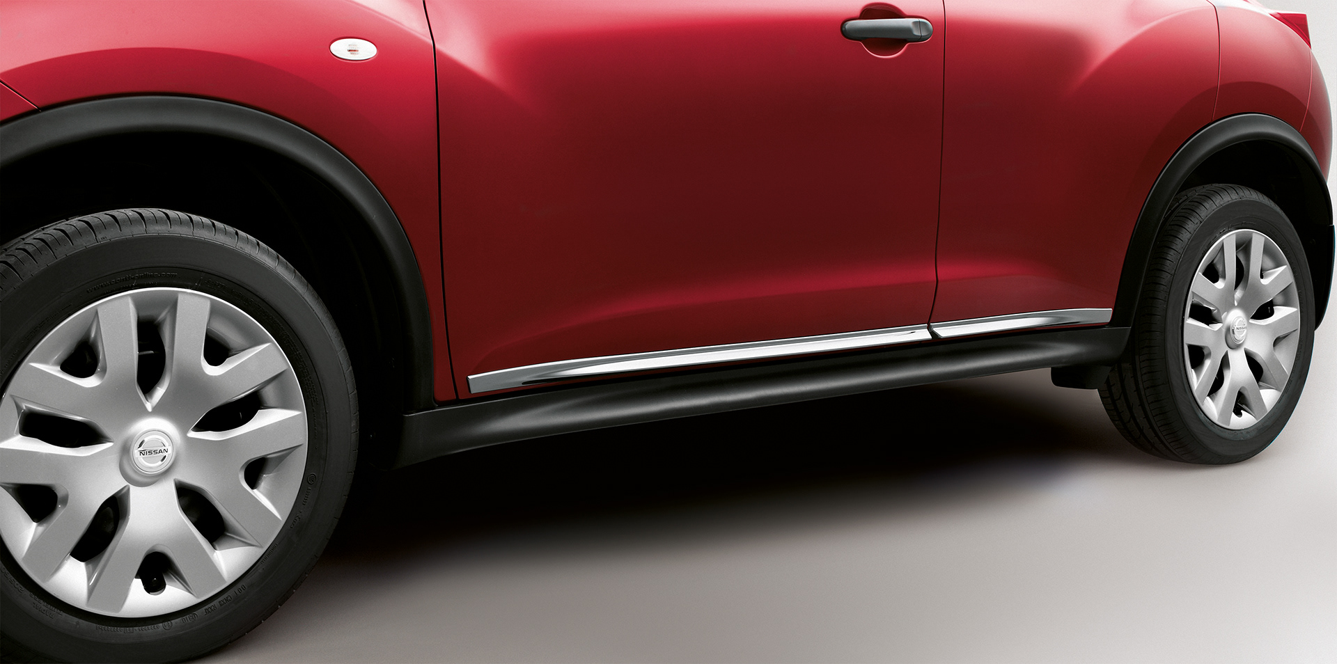 Tight crop of red Nissan Juke from the left-hand side with edits applied.