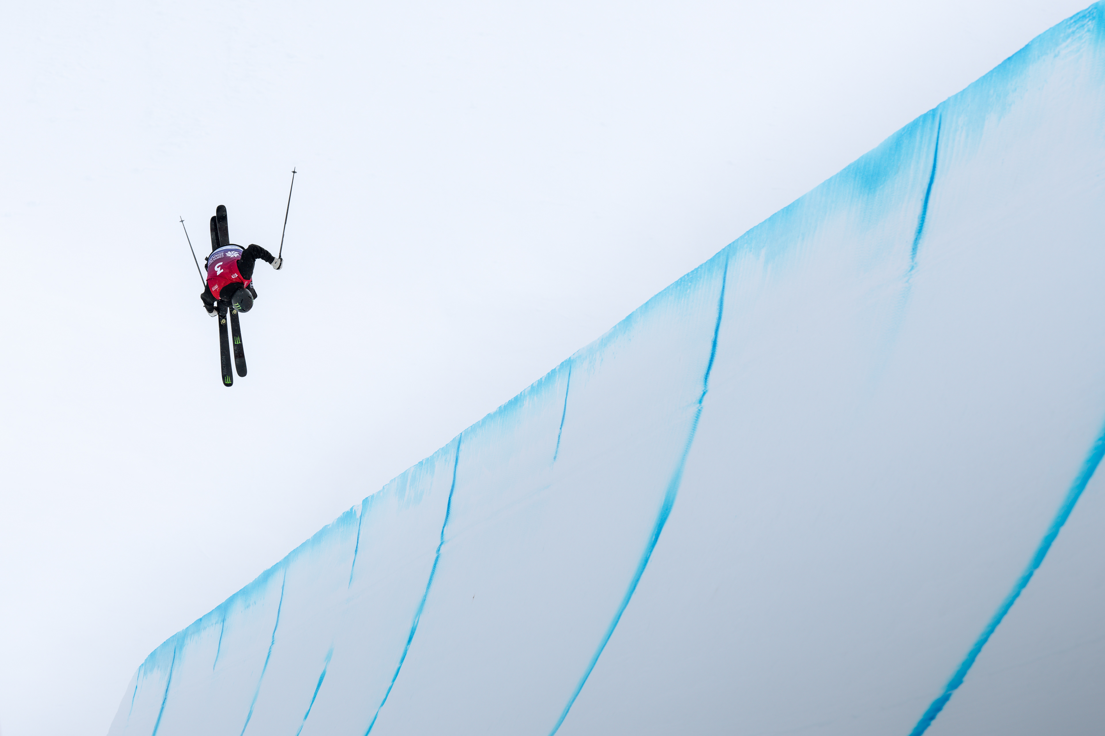 Alex Hall, Monster Energy and Faction Skis Athlete high above the quarter pipe on a cloudy day in Corvatsch park, Silvaplana