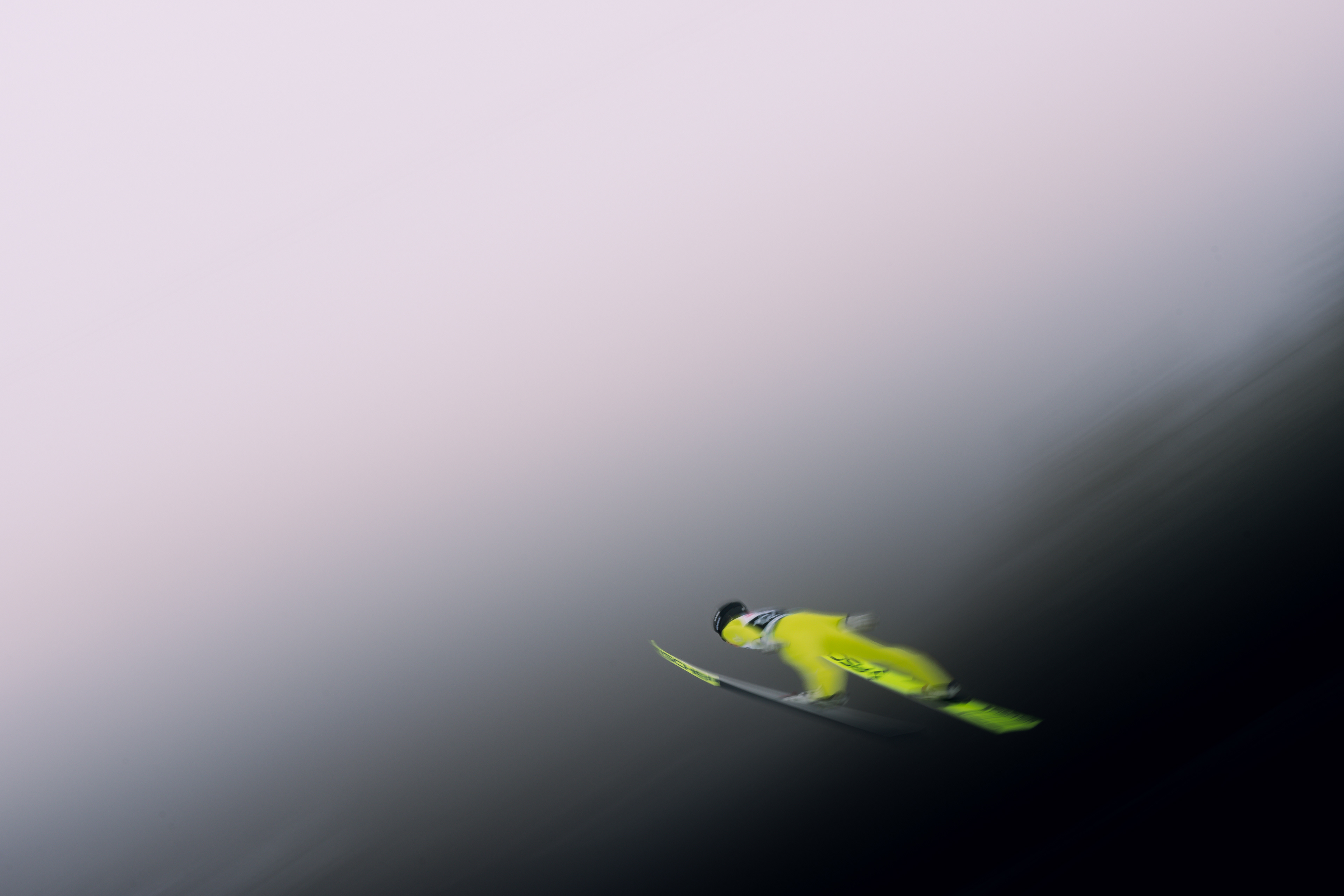 A male Ski Jumper flys through the fog with motion and grace. Professional Photographer. Ski Jumping Photographer.