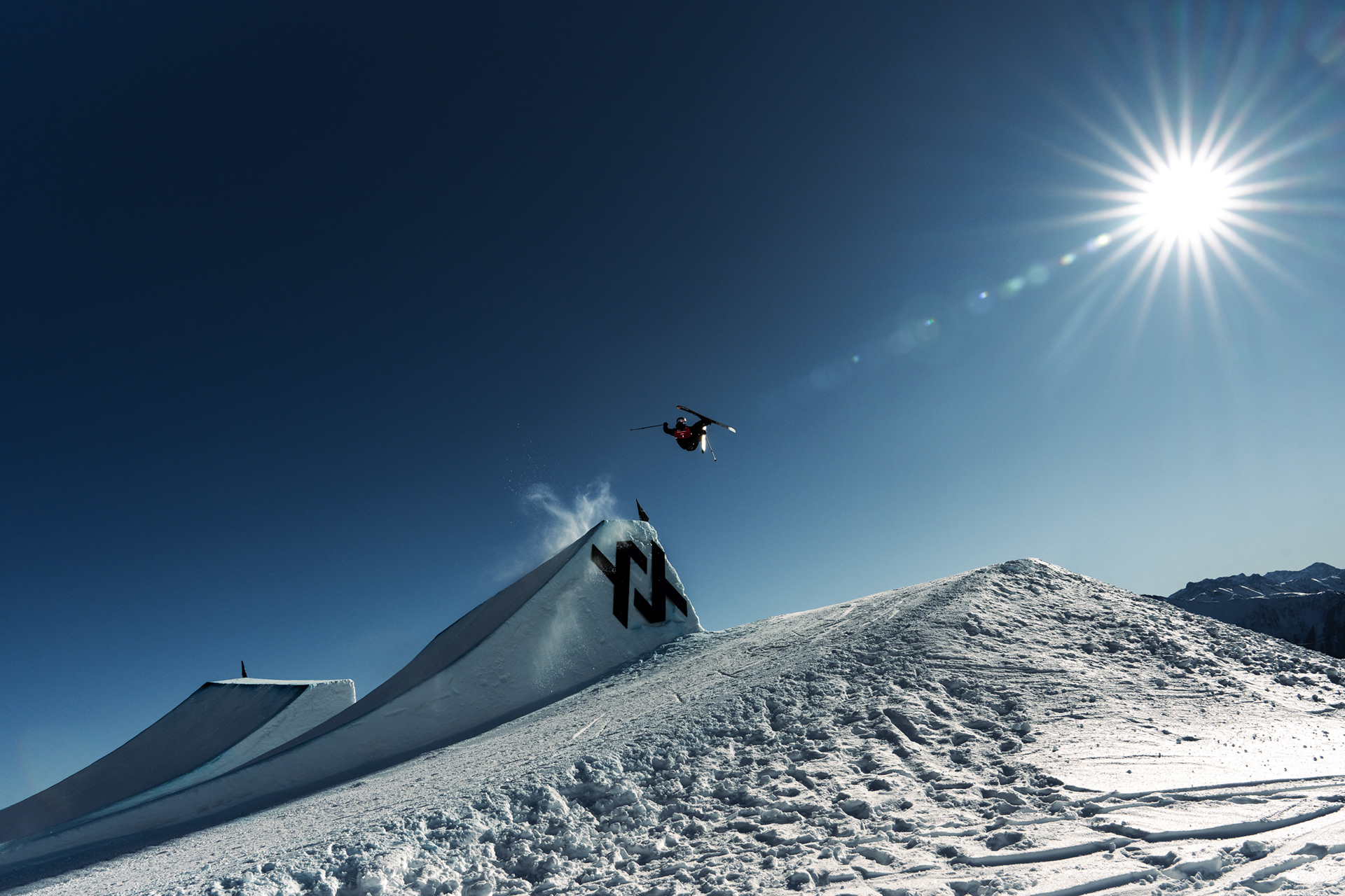 Mac Forehand on the "twisted sisters" feature at the Laax Open 2025. Red Bull, Faction Skis, Oakley