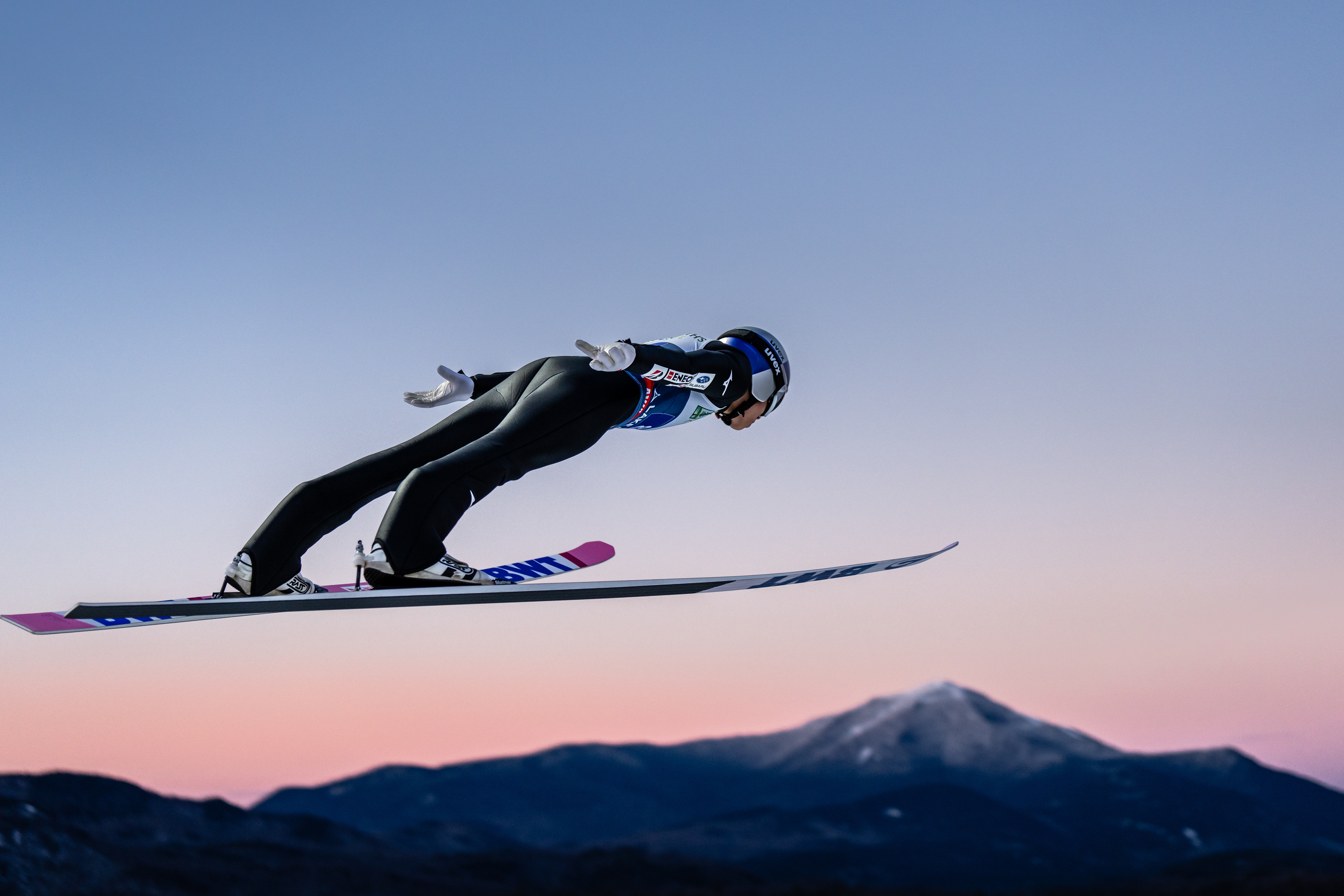 Male Japanese Ski Jumper Ryoyu Kobayashi jumps above Whiteface mountain in Lake Placid. Lake Placid, New York. USA. Red Bull Athlete. Ski jumping Photography. Professional Sports Photographer.
