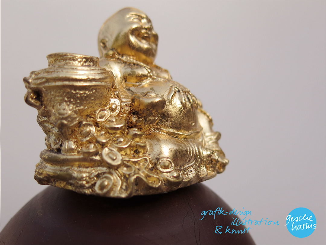 Vergoldeter Buddha "schwebt" auf Pockholzkugel, Detail aus der Froschperspektive