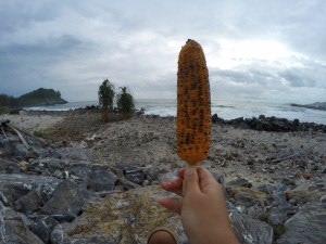 Eating grilled corn by the beach
