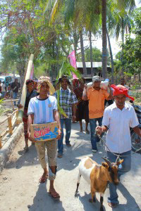 The locals carry the food offerings towards Kepa Island