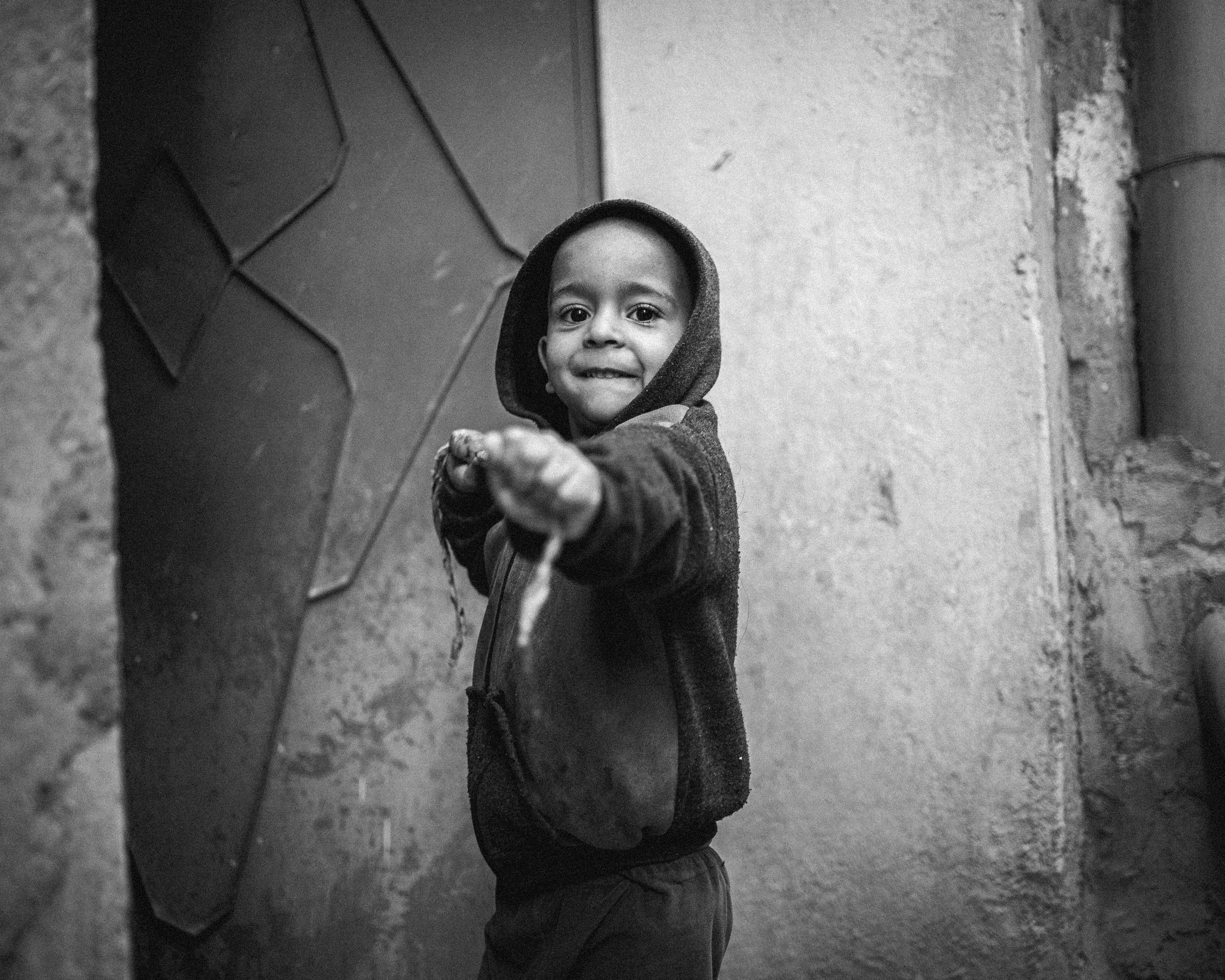 Un bambino, fuori il portone di casa sua, in Marocco.