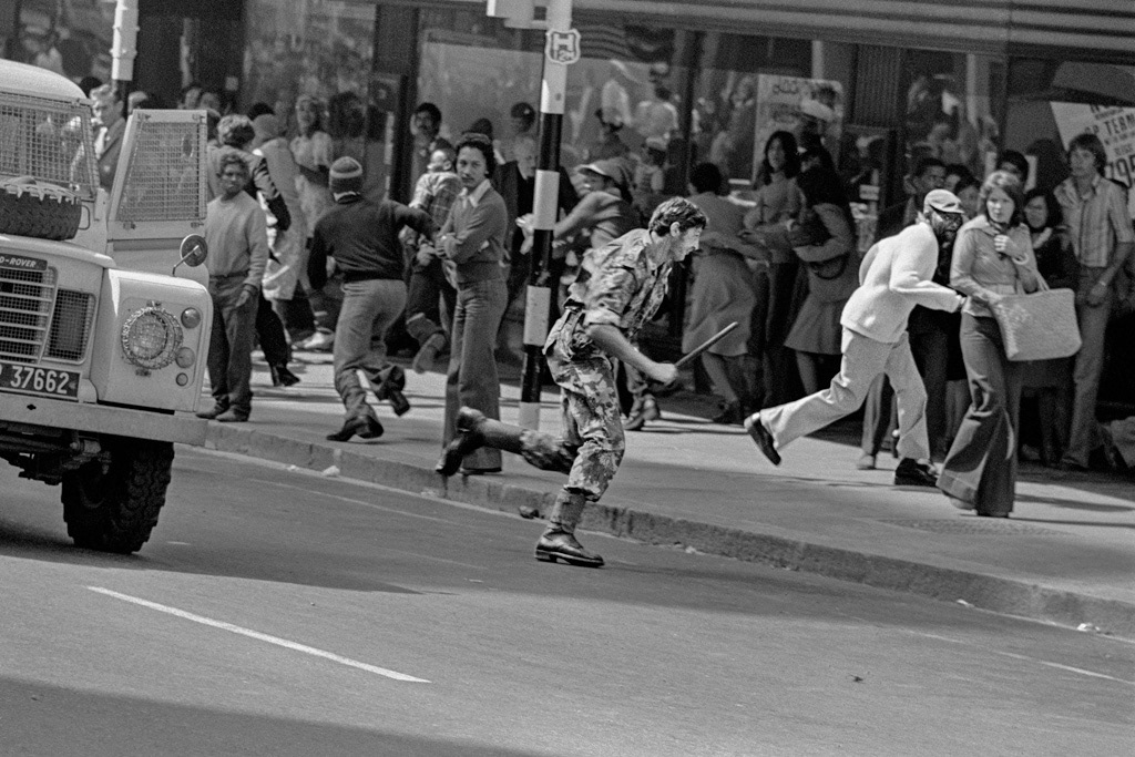 A policeman jumps out of his van and chases a man selected at random.
