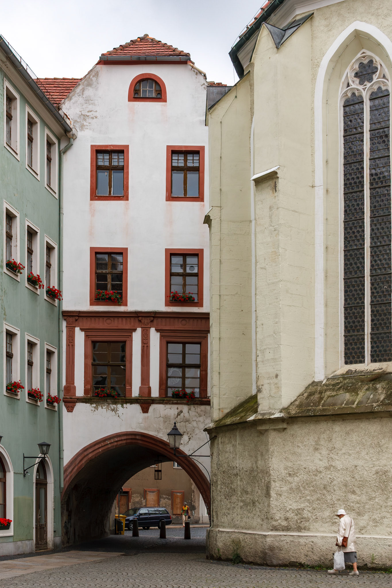 Person walking by historic church and archway