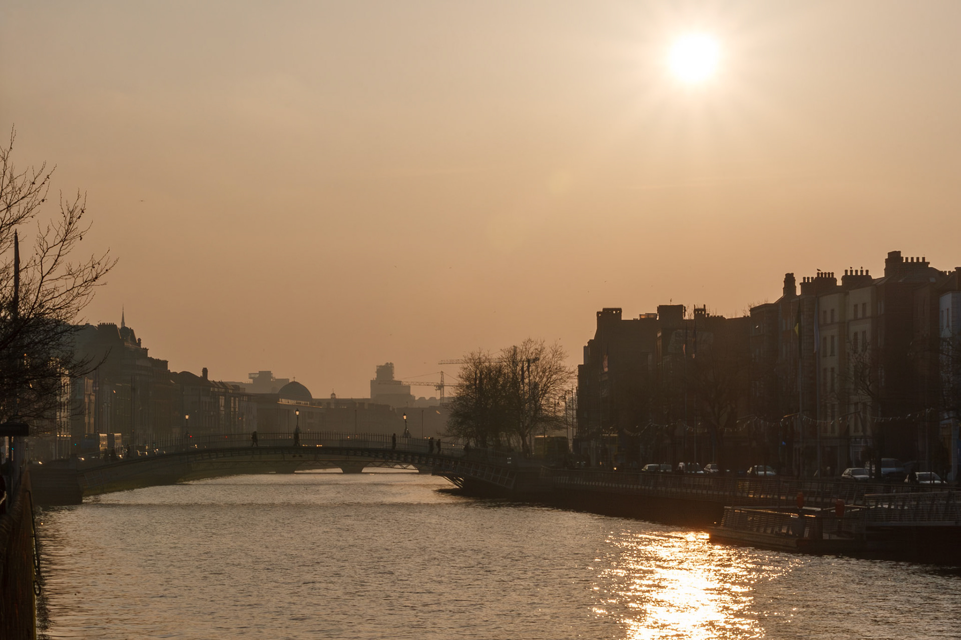 Golden sunset over a city river bridge
