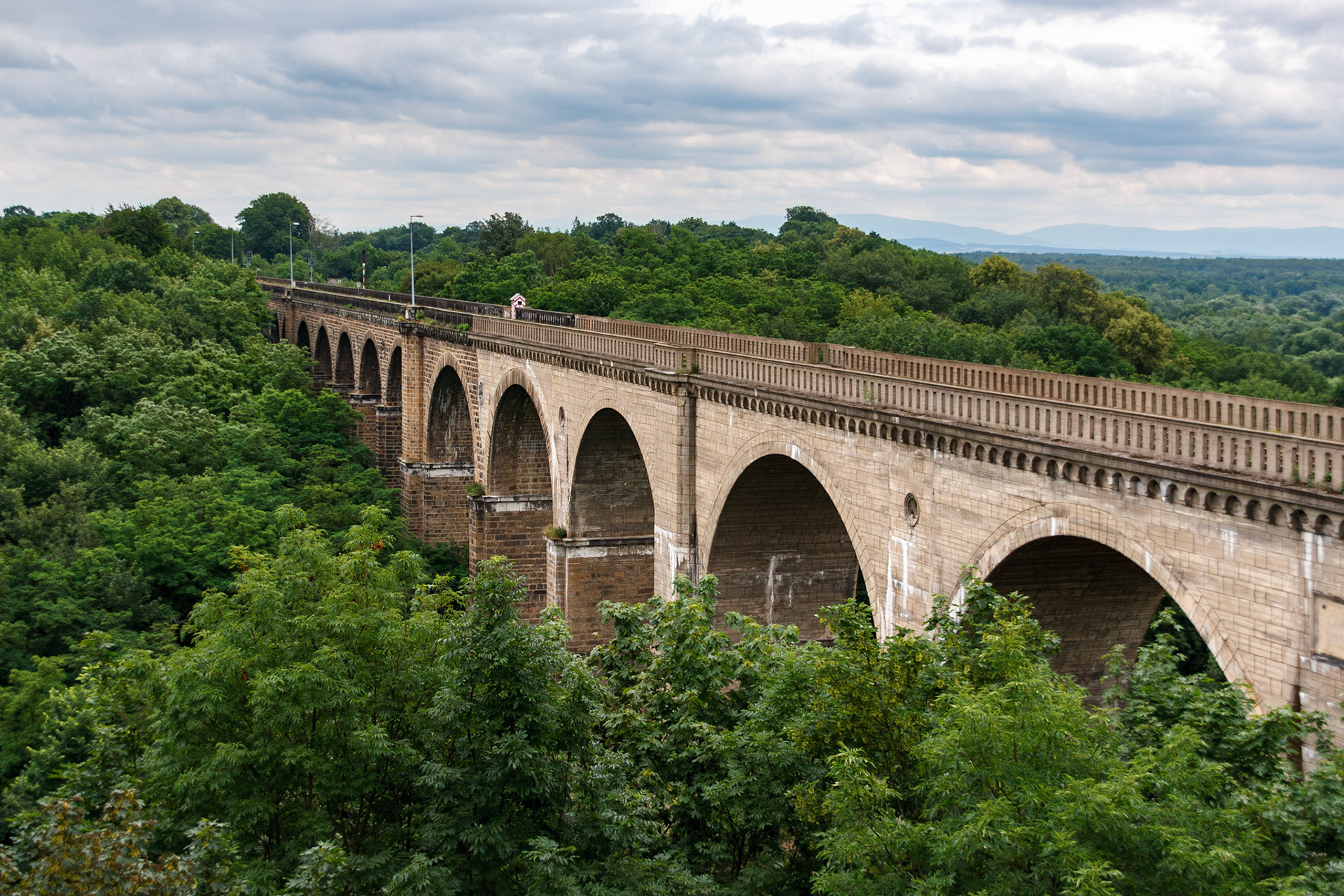 Historic stone viaduct over lush forest