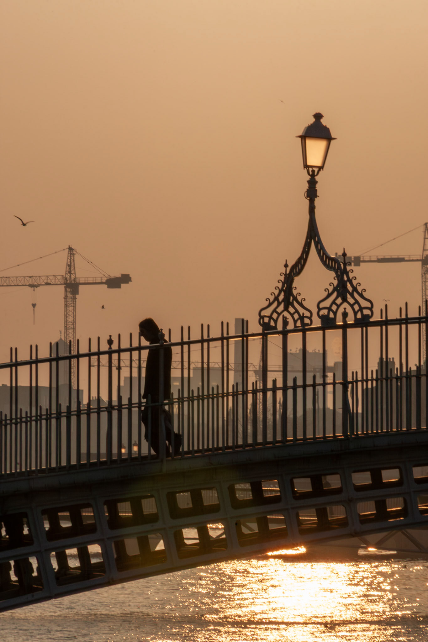 Person walking across a historic bridge