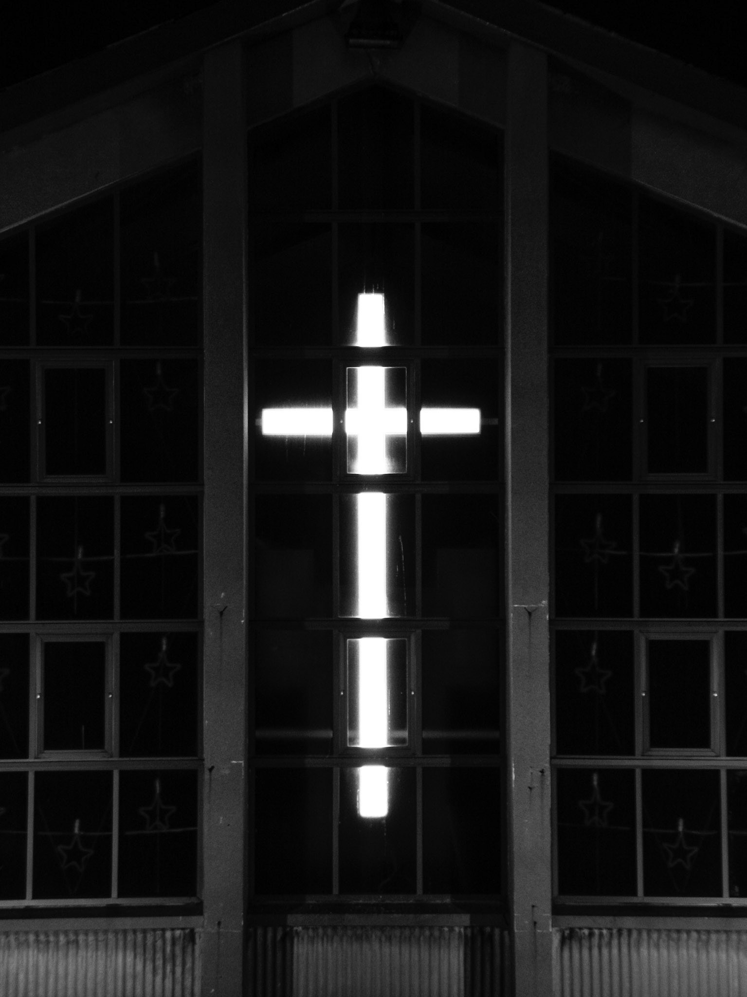 Illuminated Stained-Glass Cross Facade at Night