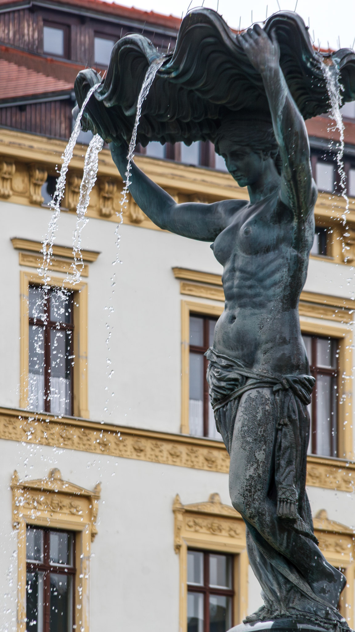 Bronze female statue holding a shell fountain
