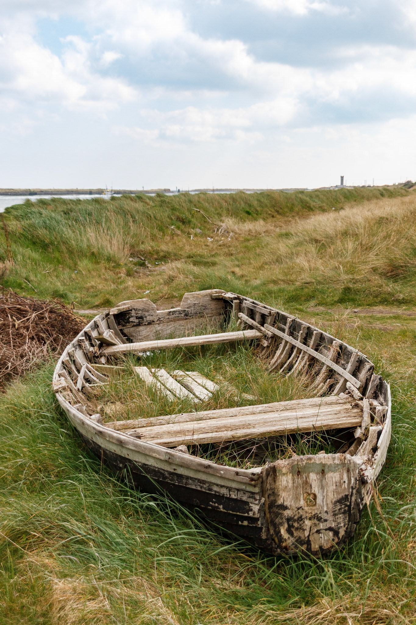 Abandoned wooden boat in a grassy field