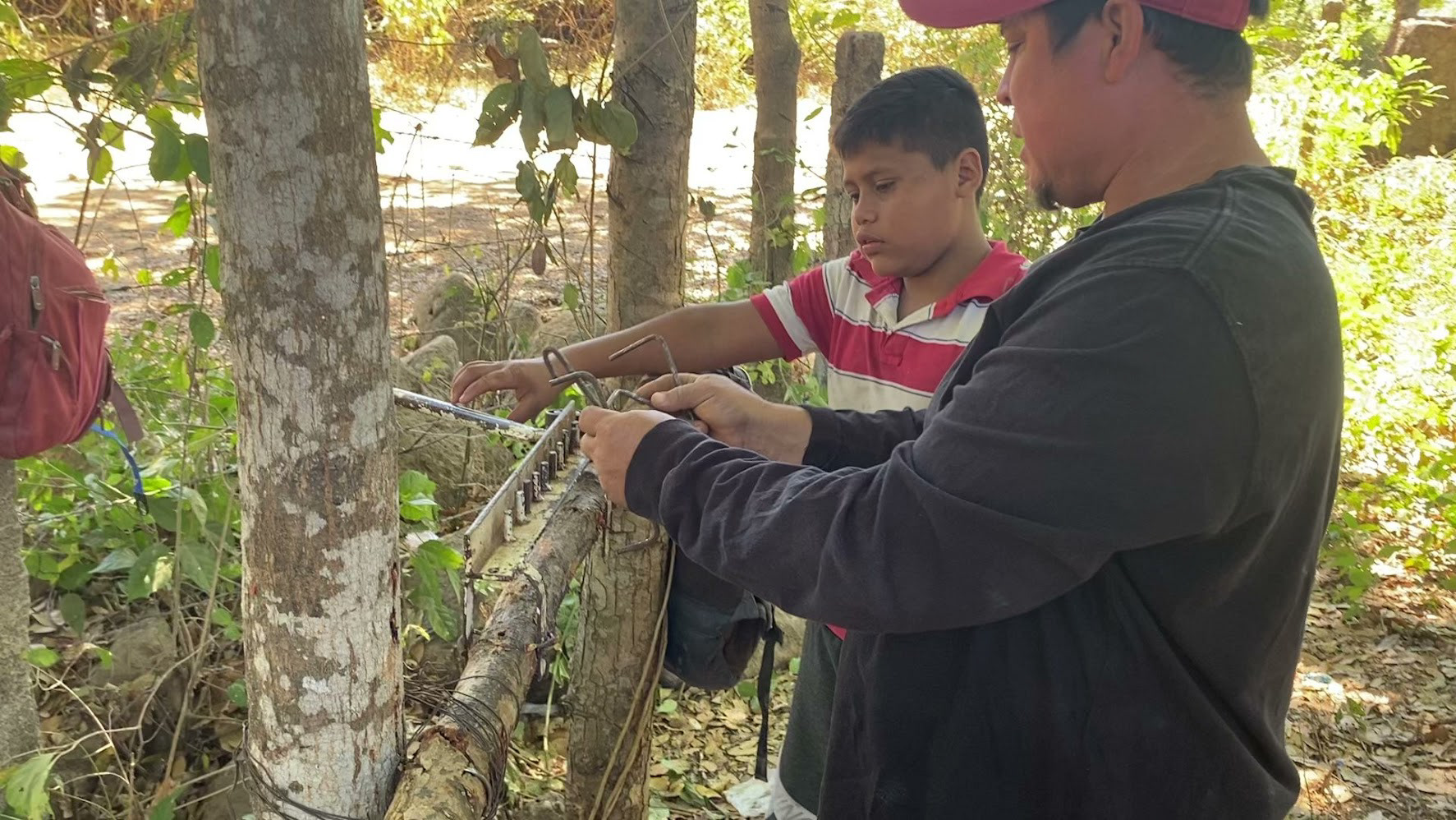 Sergio (the head mason) teaching one of the boys in the village how to bend wire.