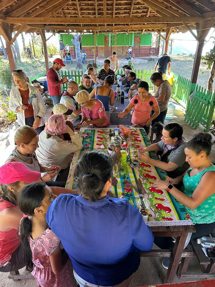 The women from the village teaching us how to weave baskets with pine needles and thread.