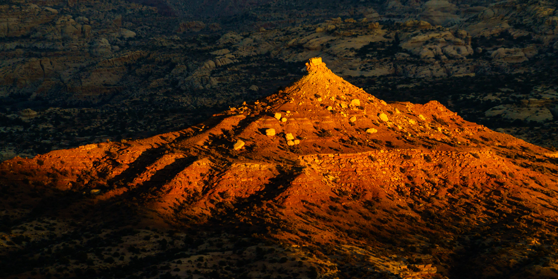 This particular butte located deep in the Maze District of Canyonlands National Park caught my attention as I was setting up camp for the night. While I noticed a gap between the flat to my southwest that might allow a window of golden hour light to illuminate the butte, I could only wait to see if the light would work in my favor. As the sun began to set, the warm light remained on the butte while lifting away from the surroundings. Elated, I began capturing. I managed to take a few exposures in the seconds before the light eclipsed the tip of the butte and the exhibition was over. The Maze, Canyonlands National Park, is known as the most inaccessible part of the most inaccessible National Park in the contiguous United States. While the Maze is indeed a maze of stunning canyons, I created 'Canyonlands Boudoir' to show the warm, seductive sandstone has equally spectacular flats, terraces, and, of course, buttes. This particular butte located deep in the Maze District caught my attention as I was setting up camp for the night. While I noticed a gap between the flat to my southwest that might allow a window of golden hour light to illuminate the butte, I could only wait to see if the light would work in my favor. As the sun began to set, the warm light remained on the butte while lifting away from the surroundings. Elated, I began capturing. I managed to take a few exposures in the seconds before the light eclipsed the tip of the butte and the exhibition was over. Because I forgot to secure my camera batteries inside of my sleeping bag while the outside temperature dropped into the 10s Fahrenheit, my batteries were all completely depleted when I woke up the next day and 'Canyonlands Boudoir' was the last image of my time in the Maze. The Maze, Canyonlands National Park, is known as the most inaccessible part of the most inaccessible National Park in the contiguous United States. While the Maze is indeed a maze of stunning canyons, I created 'Canyonlands Boudoir' to show the warm, seductive sandstone has equally spectacular flats, terraces, and, of course, buttes. This particular butte located deep in the Maze District caught my attention as I was setting up camp for the night. While I noticed a gap between the flat to my southwest that might allow a window of golden hour light to illuminate the butte, I could only wait to see if the light would work in my favor. As the sun began to set, the warm light remained on the butte while lifting away from the surroundings. Elated, I began capturing. I managed to take a few exposures in the seconds before the light eclipsed the tip of the butte and the exhibition was over. Because I forgot to secure my camera batteries inside of my sleeping bag while the outside temperature dropped into the 10s Fahrenheit, my batteries were all completely depleted when I woke up the next day and 'Canyonlands Boudoir' was the last image of my time in the Maze. The Maze, Canyonlands National Park, is known as the most inaccessible part of the most inaccessible National Park in the contiguous United States. While the Maze is indeed a maze of stunning canyons, I created 'Canyonlands Boudoir' to show the warm, seductive sandstone has equally spectacular flats, terraces, and, of course, buttes. This particular butte located deep in the Maze District caught my attention as I was setting up camp for the night. While I noticed a gap between the flat to my southwest that might allow a window of golden hour light to illuminate the butte, I could only wait to see if the light would work in my favor. As the sun began to set, the warm light remained on the butte while lifting away from the surroundings. Elated, I began capturing. I managed to take a few exposures in the seconds before the light eclipsed the tip of the butte and the exhibition was over. Because I forgot to secure my camera batteries inside of my sleeping bag while the outside temperature dropped into the 10s Fahrenheit, my batteries were all completely depleted when I woke up the next day and 'Canyonlands Boudoir' was the last image of my time in the Maze.