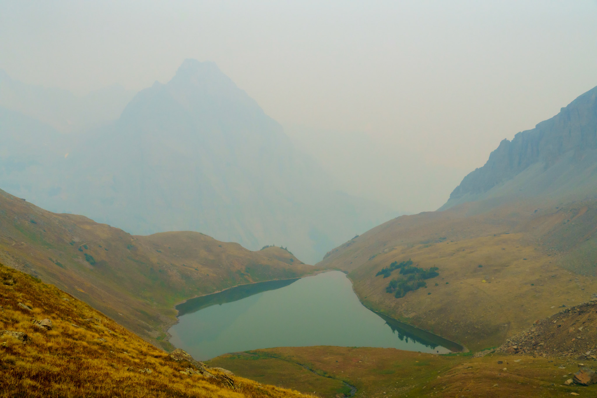 Grand Mesa, Uncompahgre and Gunnison National Forests, Although I planned to capture this scene with a vibrant alpenglow, wildfire smoke had other ideas. Disappointed, I reluctantly captured one exposure before moving on. When I looked at the capture at home, I decided that I liked the mystic feel of the lake below a nearly opaque mountain.
