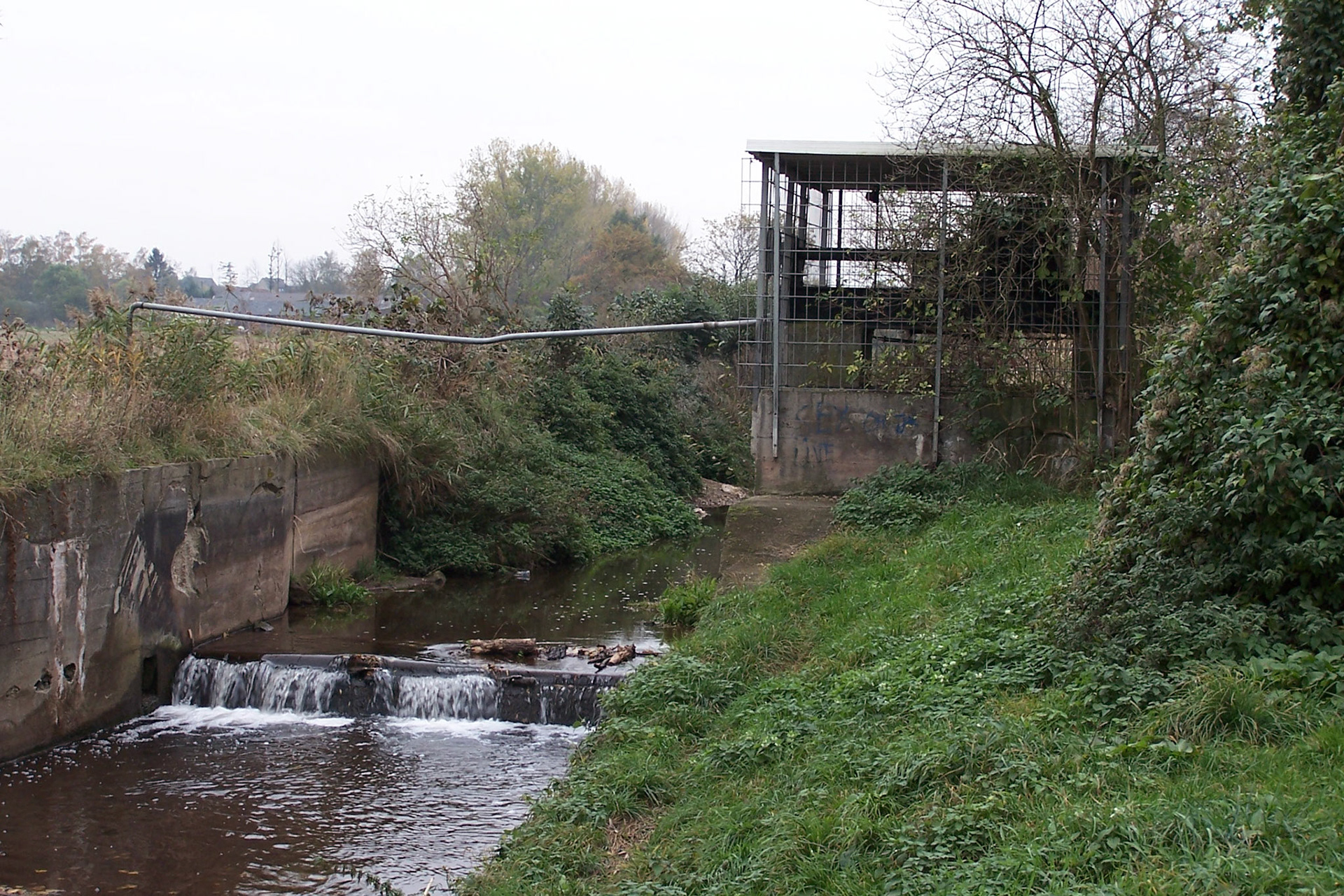 Das Bauwerk diente zur Steuerung der Staustufe am Rotbach in Friesheim. Das Gebäue wurde 2005 abgerissen und der Abschnitt des Rotbachs neu gestaltet