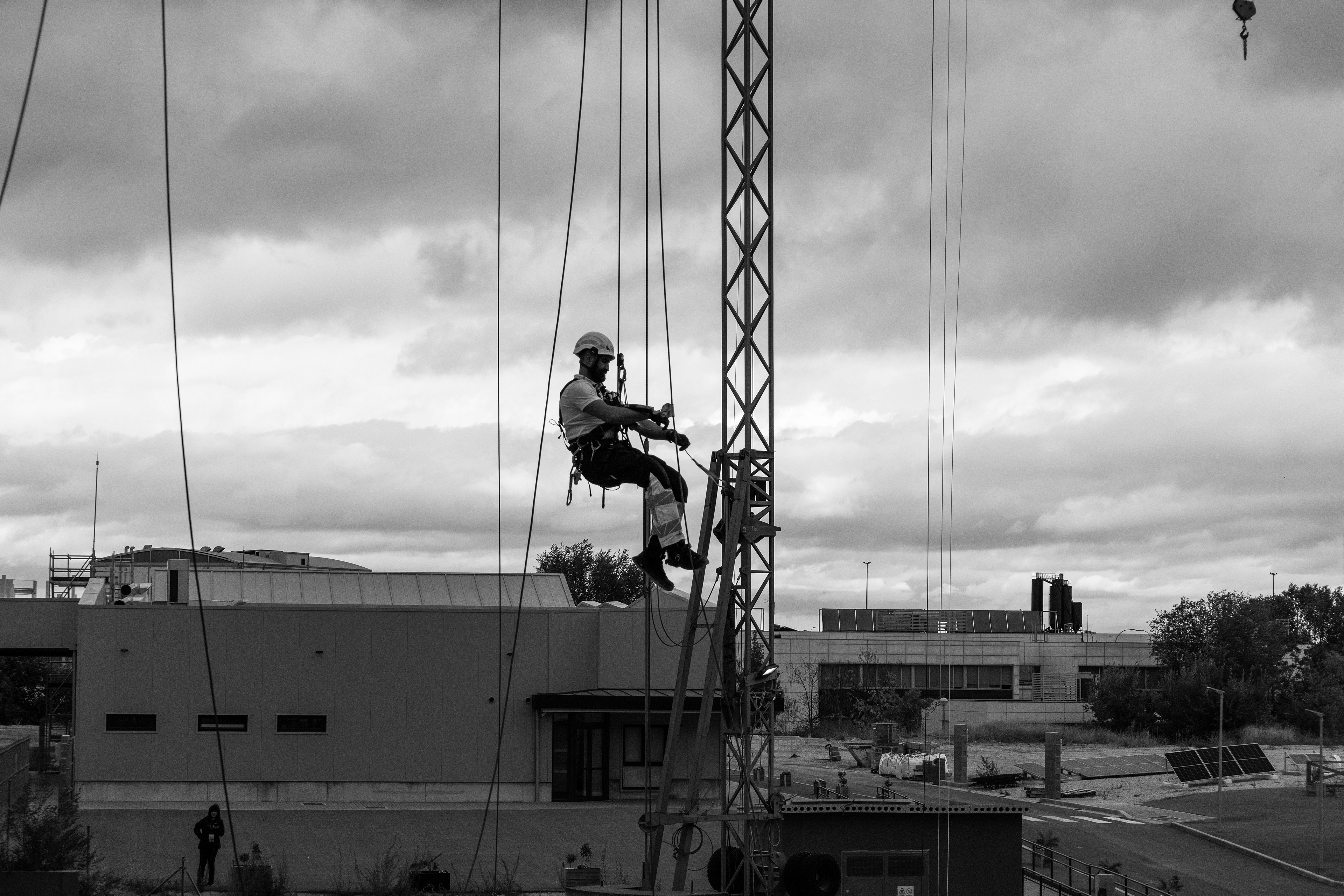 fotografía de hombre en las alturas una foto artística pero que a la vez la persona esta trabajaon y se le ve que fisfruta de lo que hace por años trabajar en alturas foto en blanco y negro   