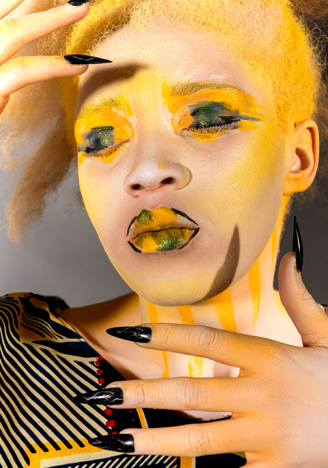 Primer plano de modelo albina con ojos claros, mostrando el rostro y parte del cuerpo pintado con body painting que simula ropa africana tradicional. Detalles artísticos en manos y torso, destacando la cultura africana y el arte corporal sobre piel clara.