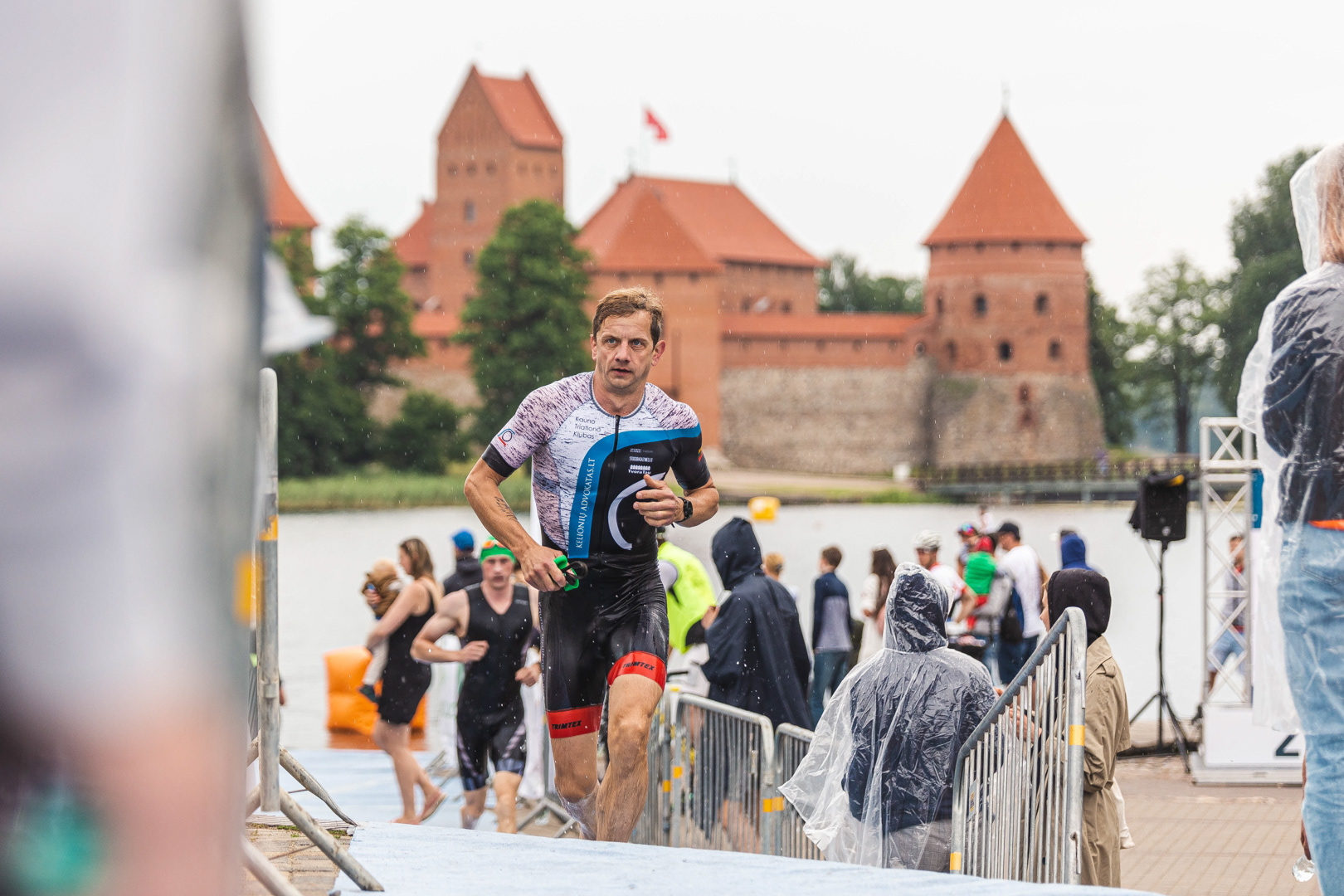 Triatloninkas po plaukimo rungties bėga į tranzito zoną Trakų triatlono 2020 metu