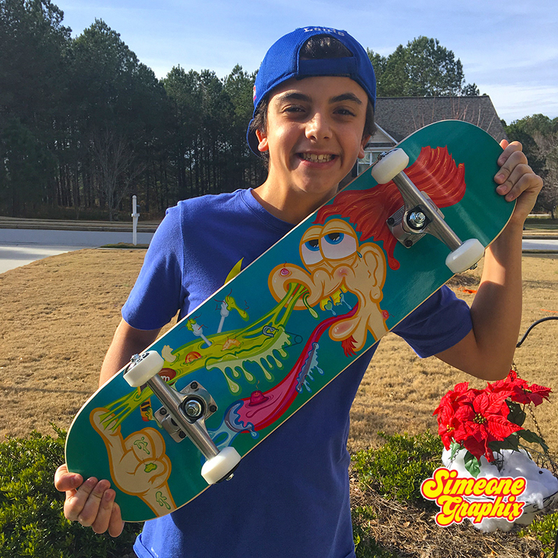happy kid outside holding a simeone graphix skateboard from Boardpusher