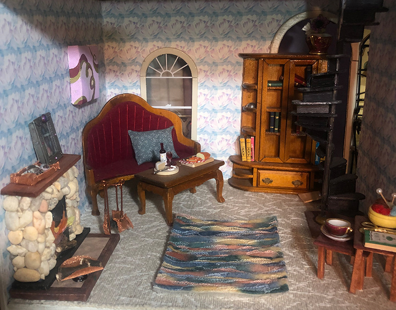 LIVINGROOM: FIREPLACE, RUG, NESTING TABLES, SPIRAL STAIRCASE, CANVAS PAINTING