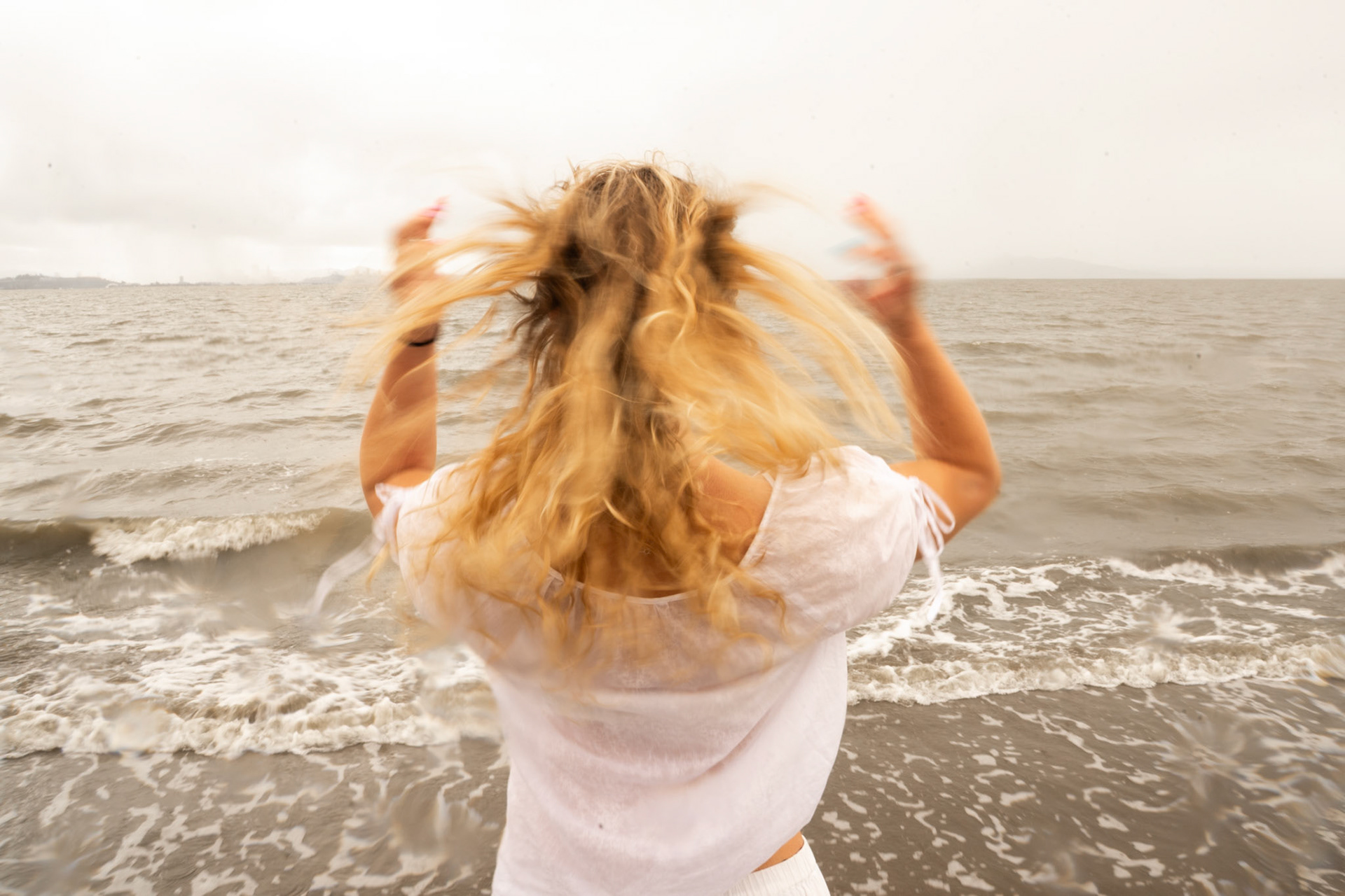 I used a low shutter speed to capture the movement of a harsh wind, using my subject's hair to visualize an invisible force.