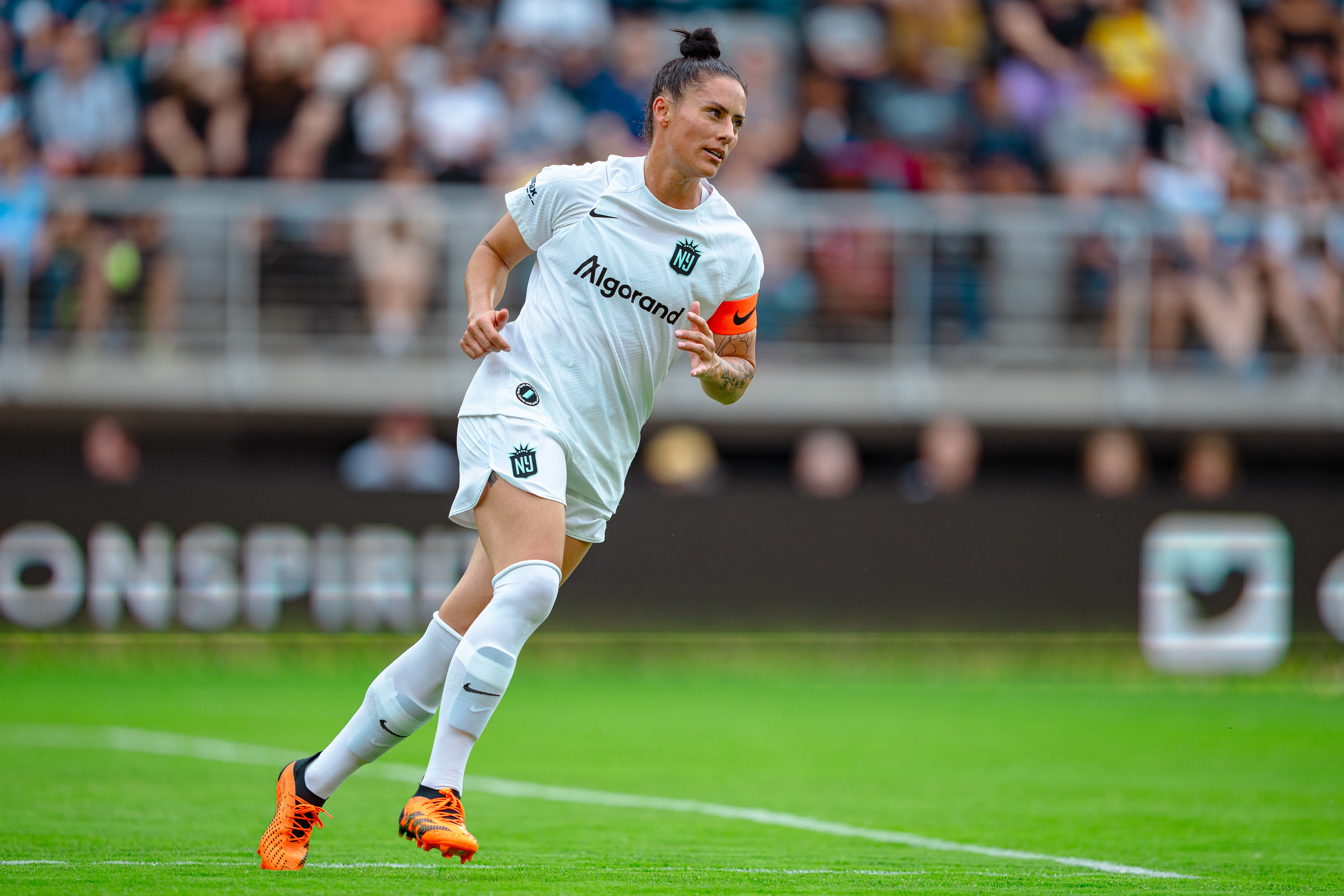 Captain Ali Krieger (11) running back to defend at Audi Field