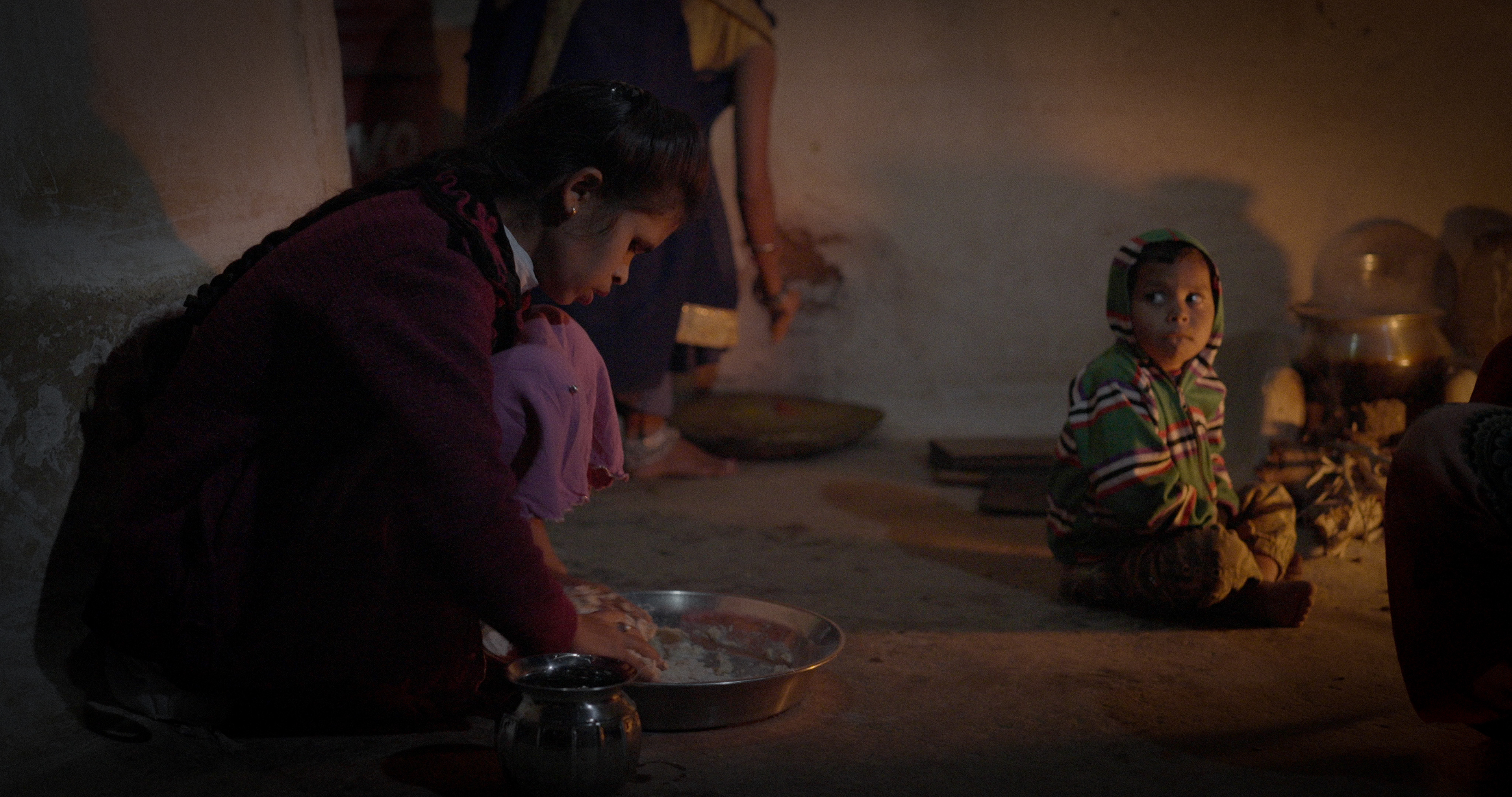 Sudhama cooking by fire at night