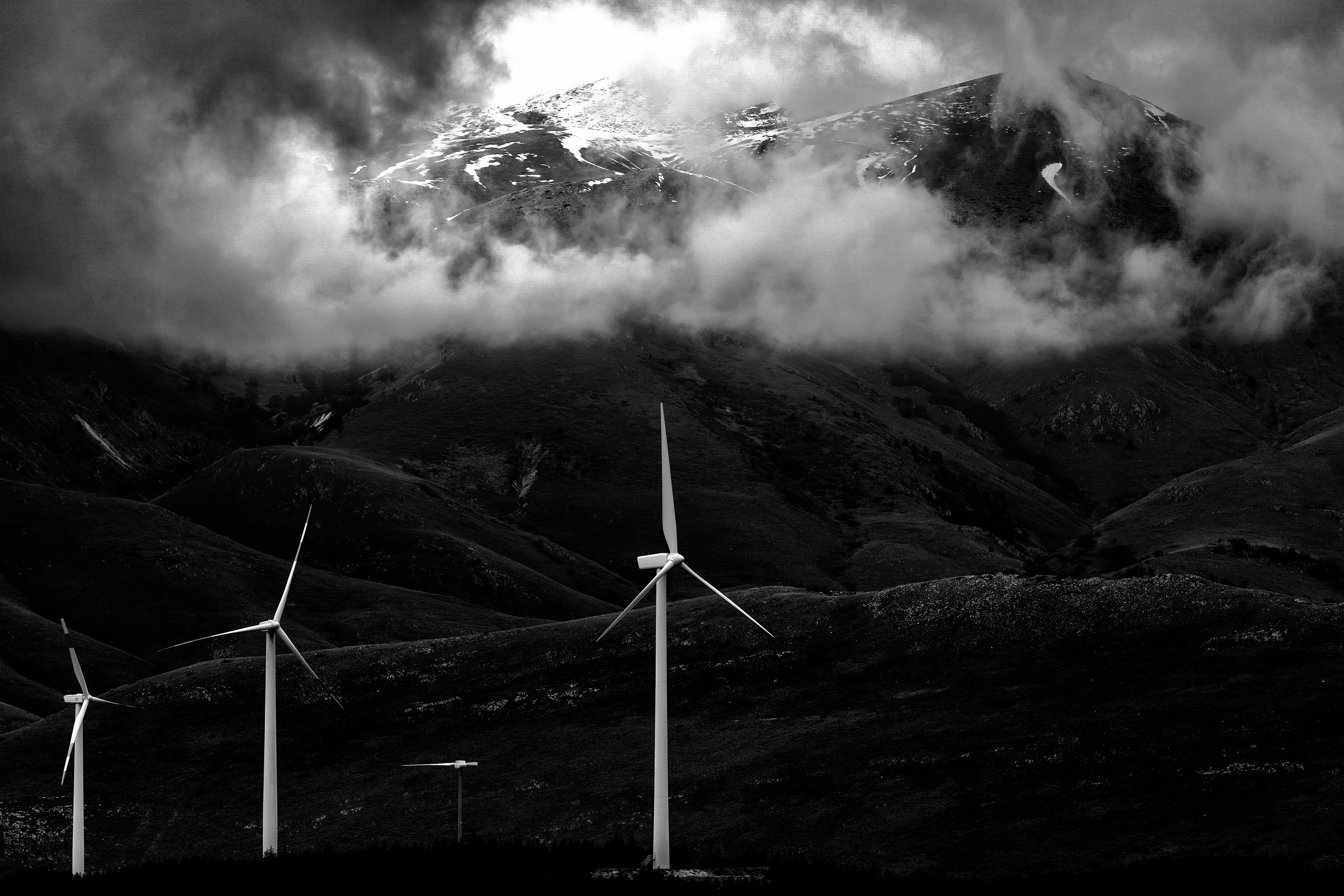 “Modern Anemoi” — wind over rock; blades in cloud. Ancient gods, modern engines.