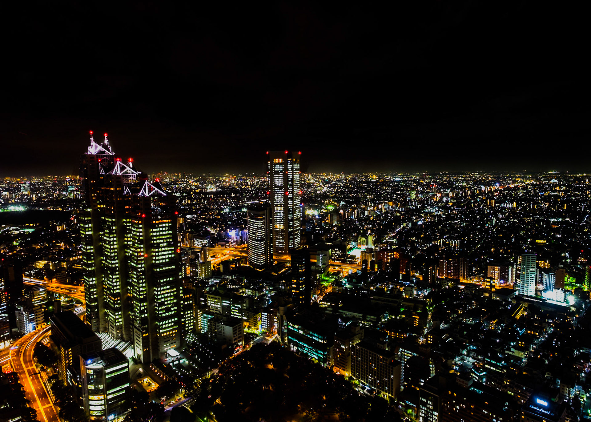Night view of Roppongi Hills with city lights shimmering in the distance
