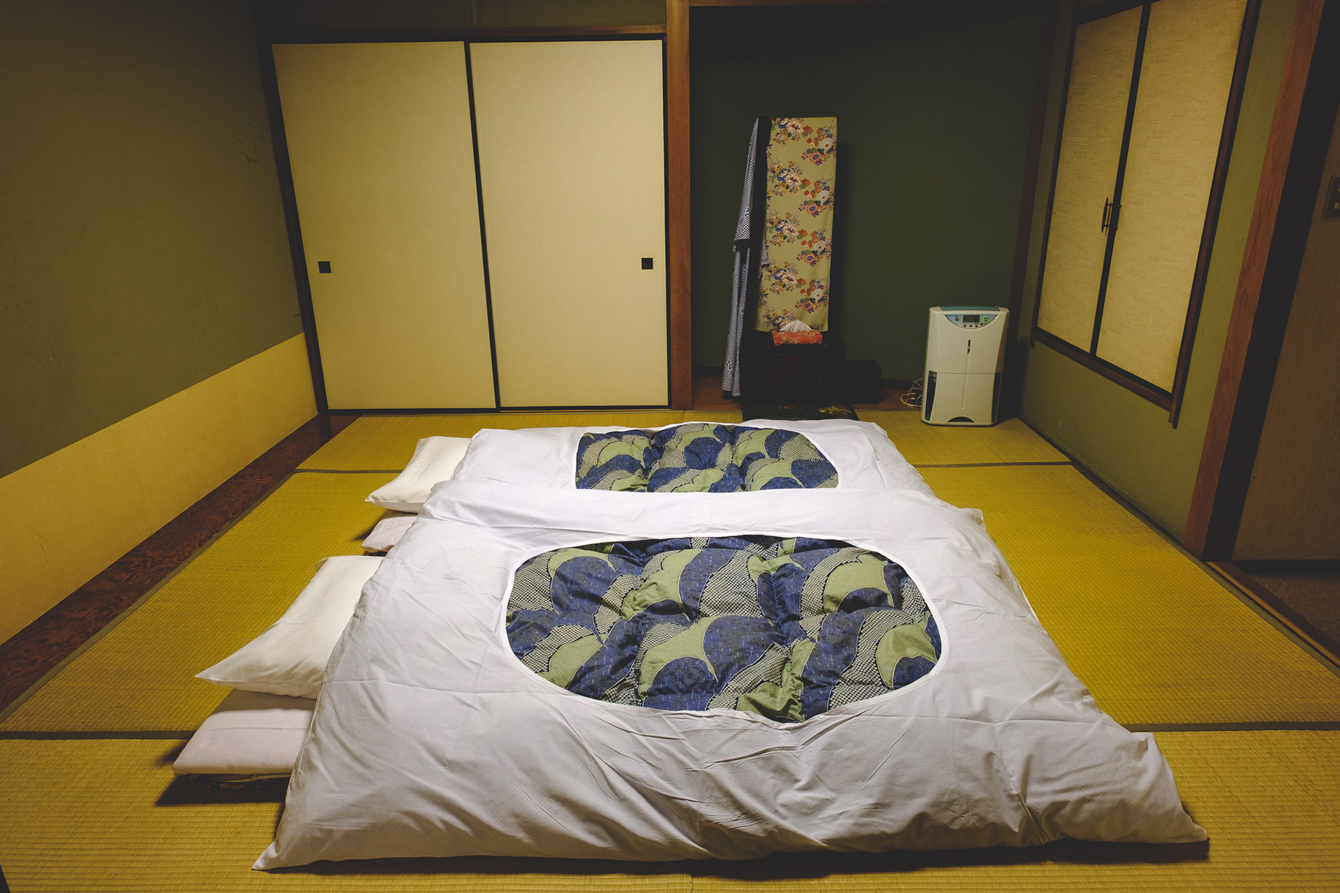 Two futons laid directly on tatami mats in a traditional Japanese ryokan bedroom, prepared for the night.