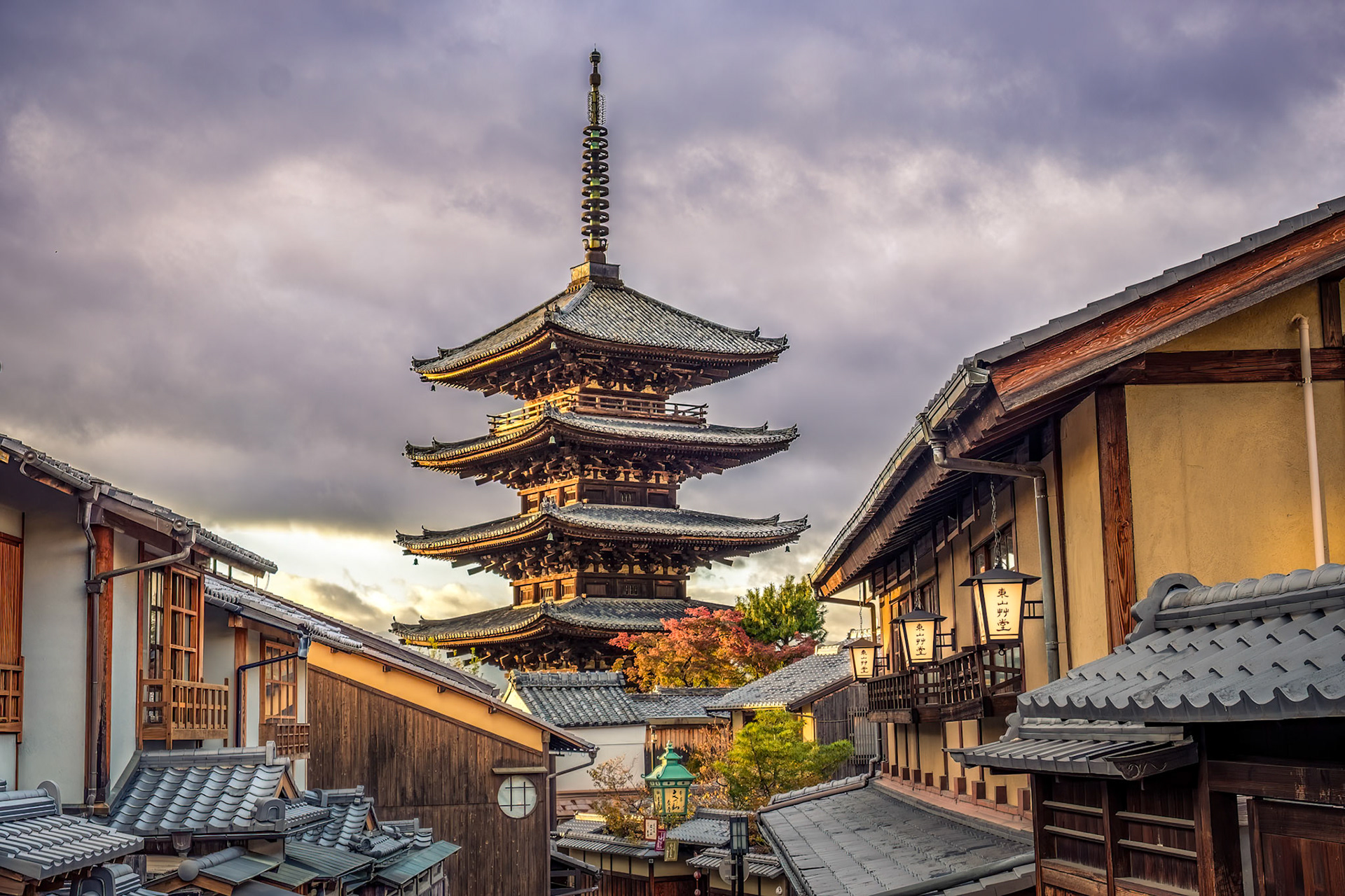 Kyoto’s Yasaka Pagoda rises over the preserved machiya lanes of Higashiyama, where lantern‑lit wooden houses evoke the city’s timeless charm at dusk.
