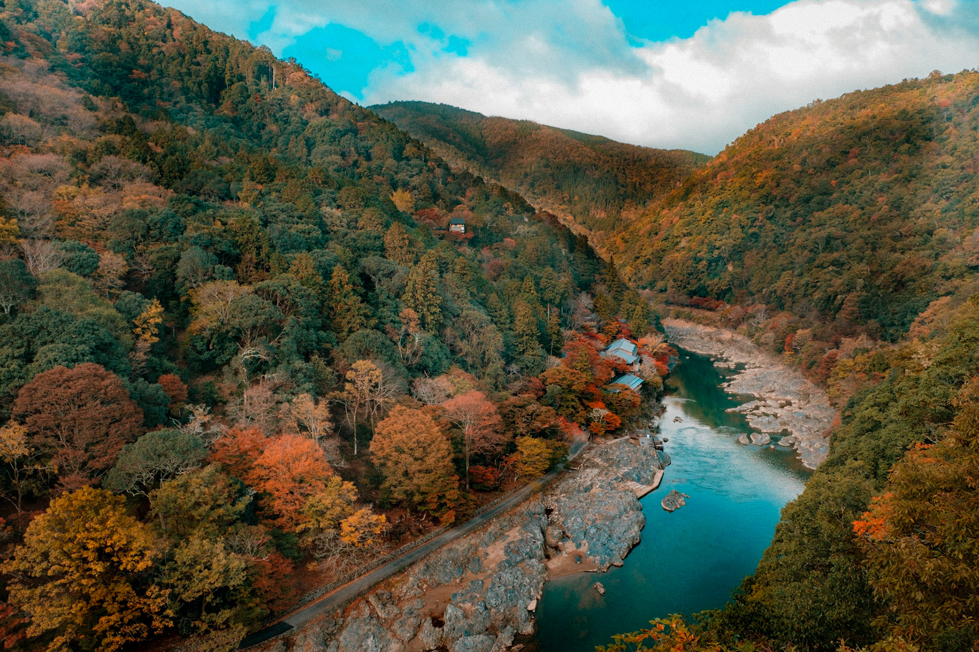 In Kyoto’s Arashiyama region, the jade‑coloured Hozu River carves through a blaze of autumn maples and cedar‑clad mountains, inviting boat rides along its vibrant canyon.