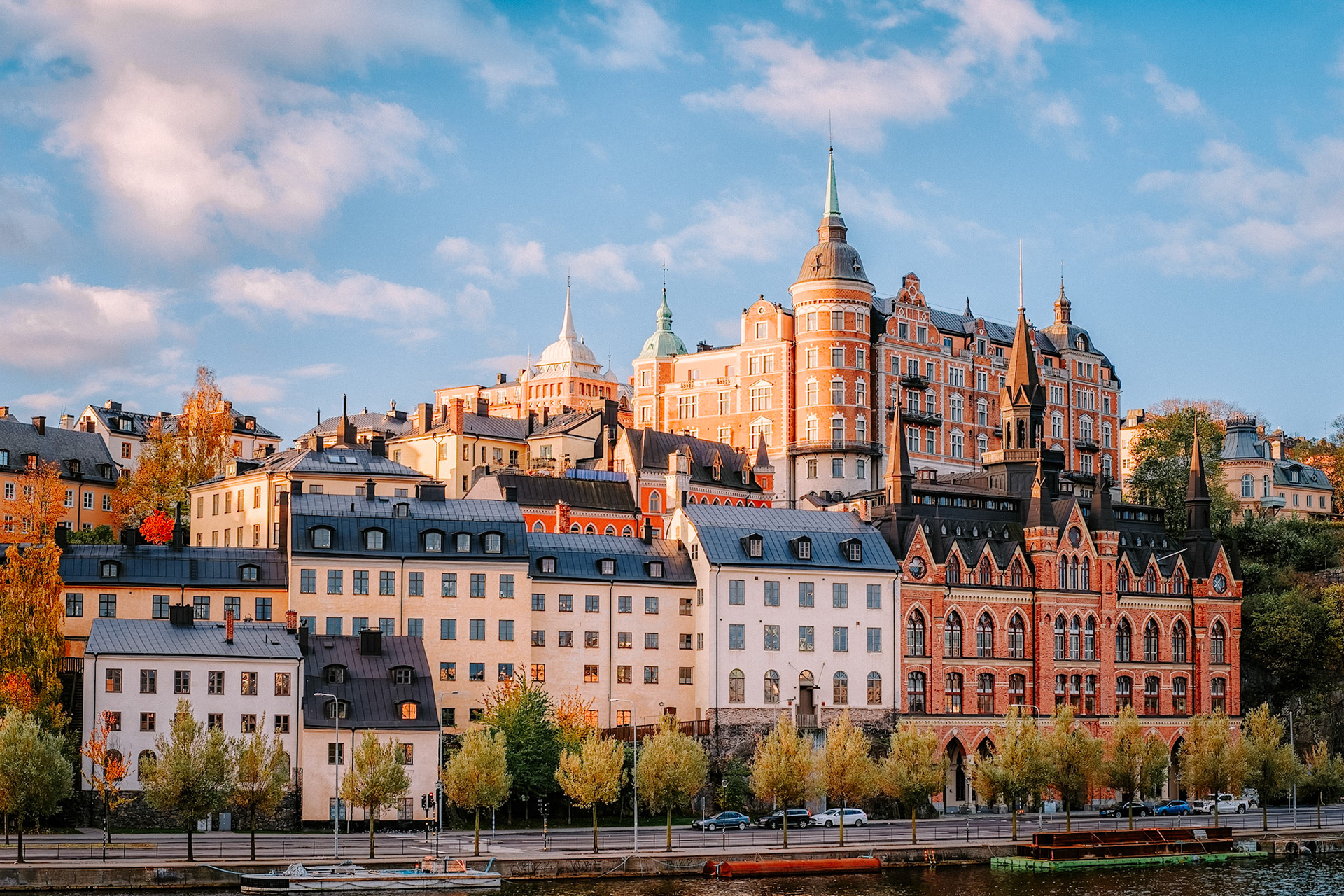 The stately towers and pastel facades of Stockholm’s Södermalm rise above Söder Mälarstrand, bathed in golden morning light along the Riddarfjärden shoreline.