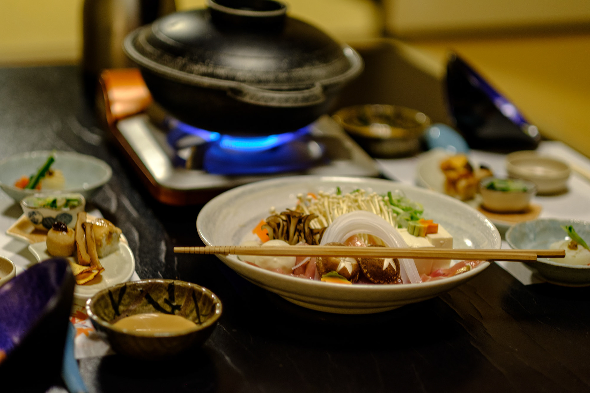 Ingredients for our shabu-shabu simmering ritual, surrounded by small kaiseki dishes waiting their turn.