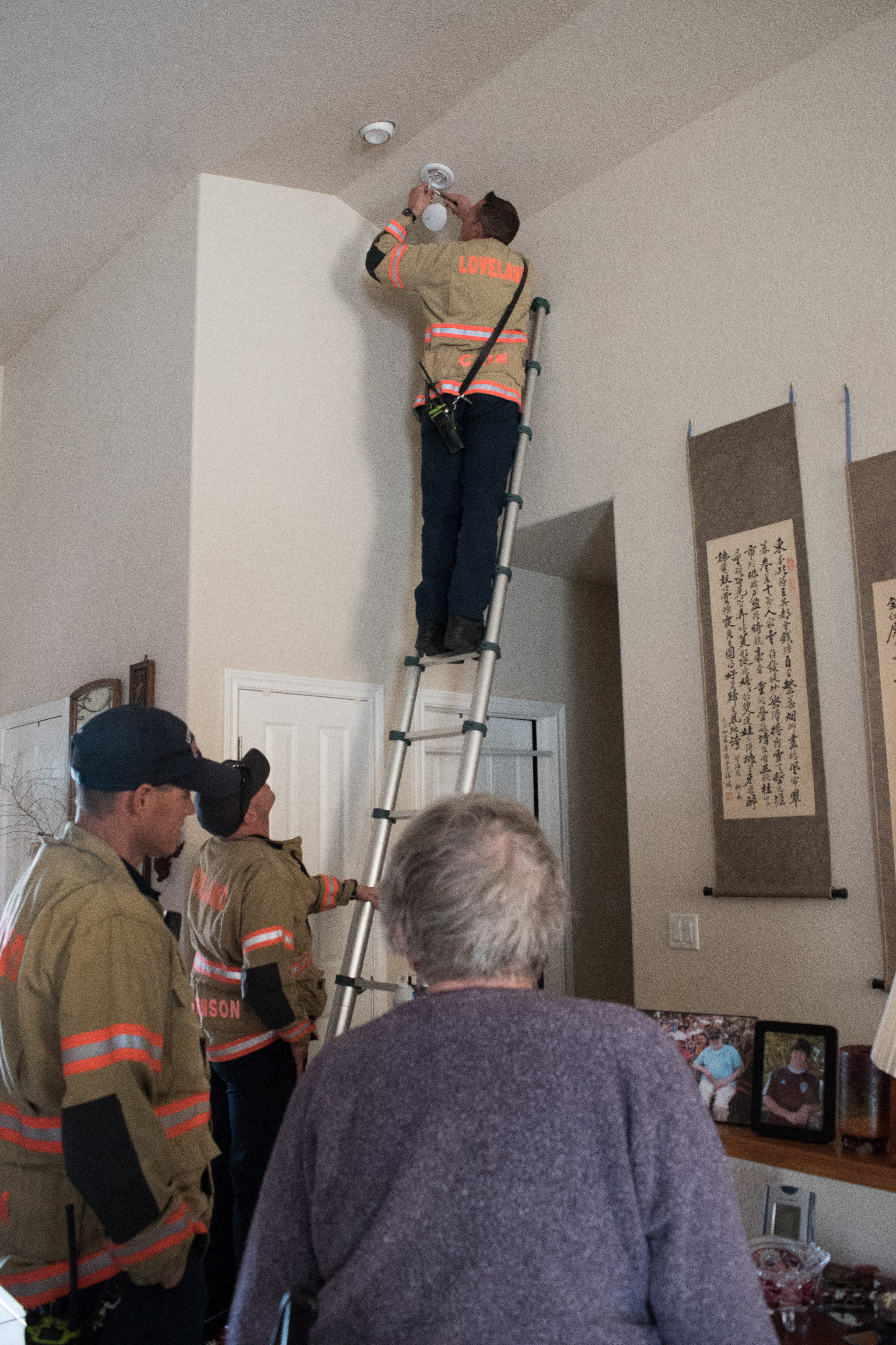 Zack Cain changes out smoke detector batteries in a citizen's home, April 5, 2018.