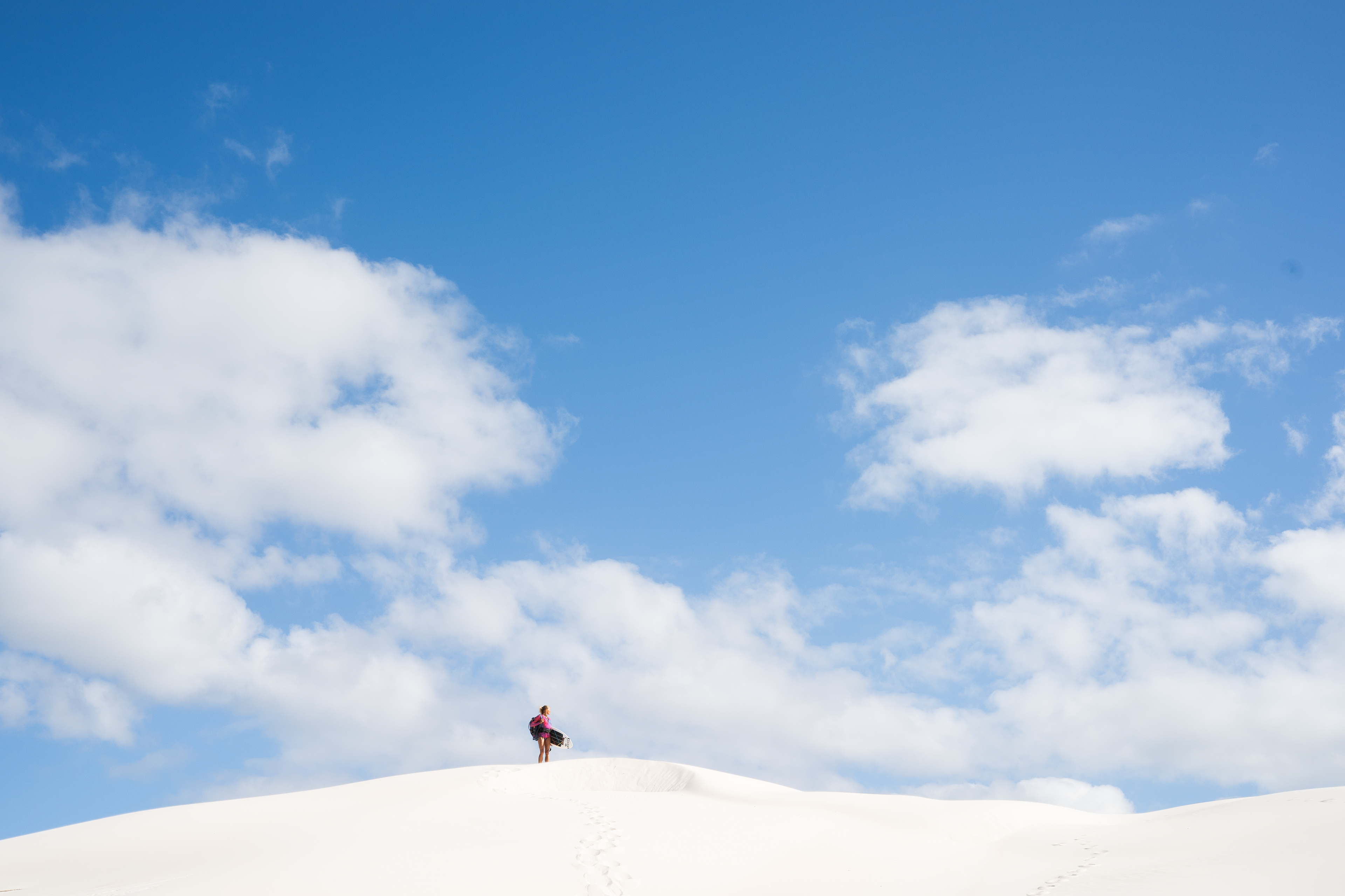 Gabi Steindl hiking through white sand dunes on the search for waves ©MiriamJoanna