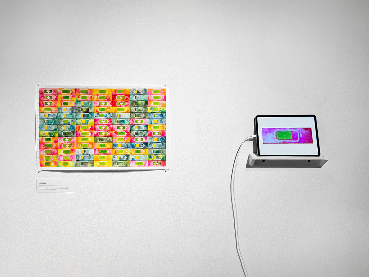 Watercolor painting with grid of social battery icons, about 2.5 feet by 1.5 feet pinned to white wall. On shelf to the right, an iPad loops an animation of each battery icon in the grid.