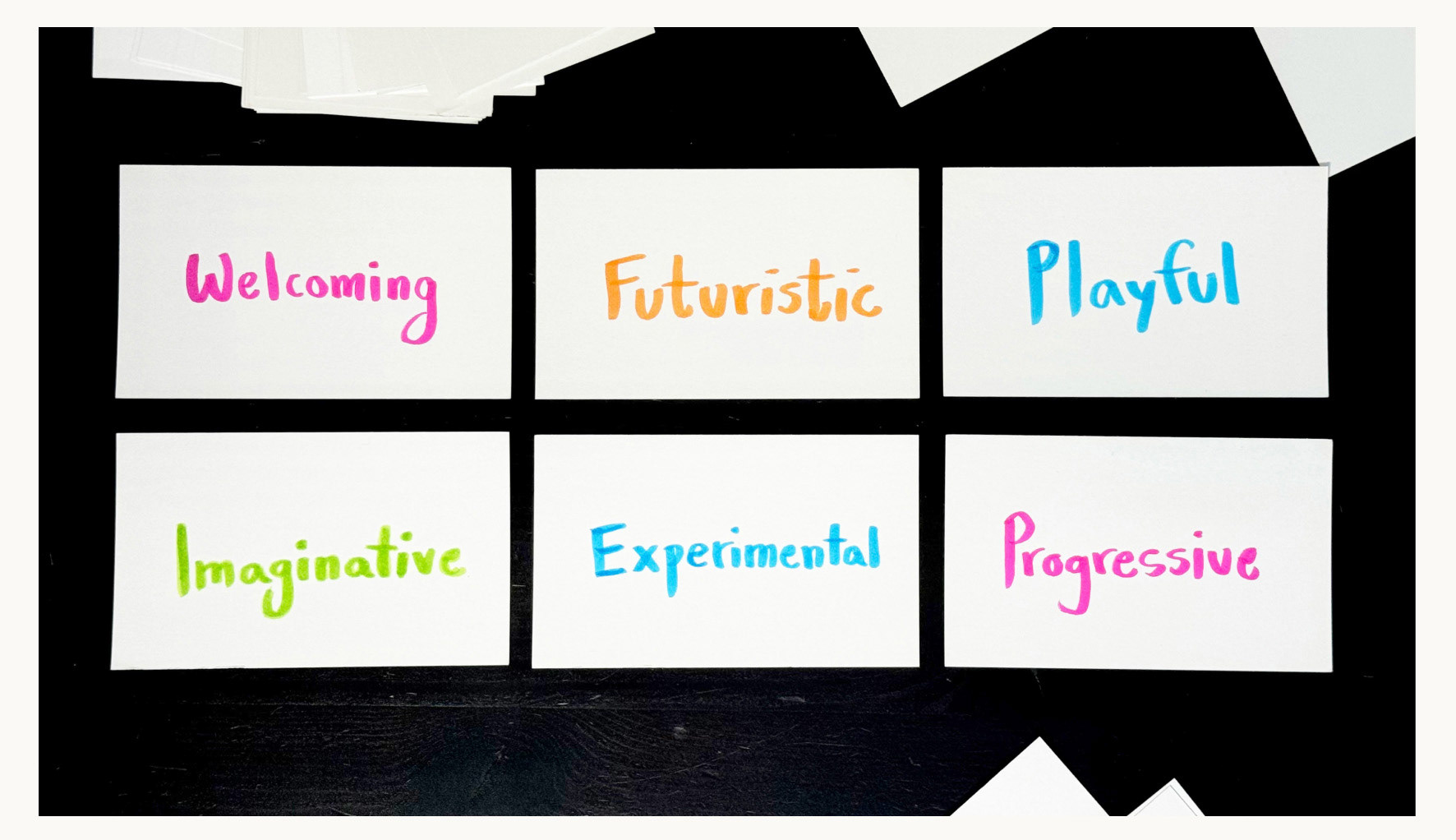 6 index cards, each with displaying a marker-written value: Welcoming, Futuristic, Playful, Imaginative, Experimental, Progressive