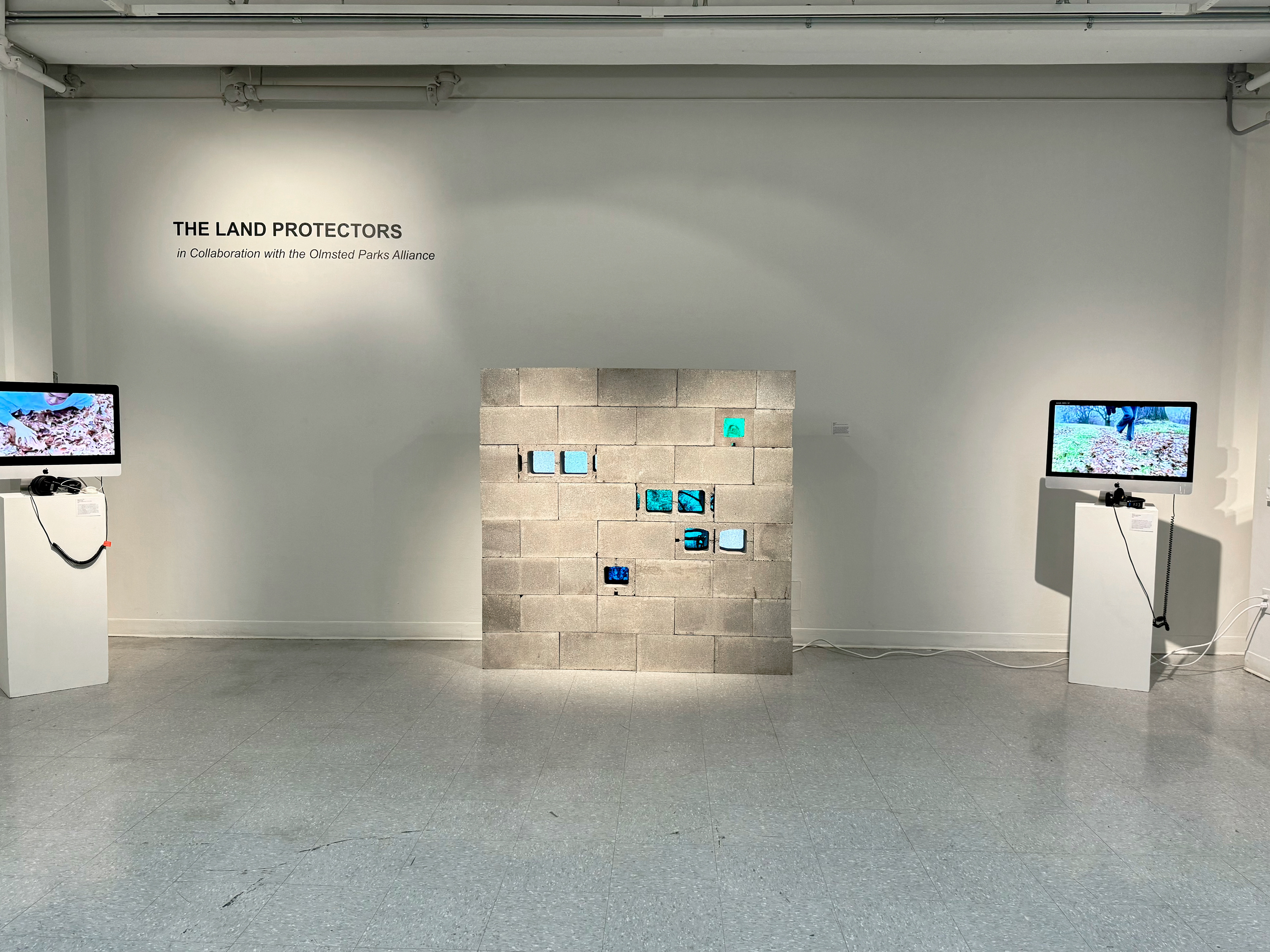 5 foot by 5 foot installation made of stacked cinder blocks. Some of the cinder blocks are turned so 8 windows open to green and blue screens displaying nature videos.
